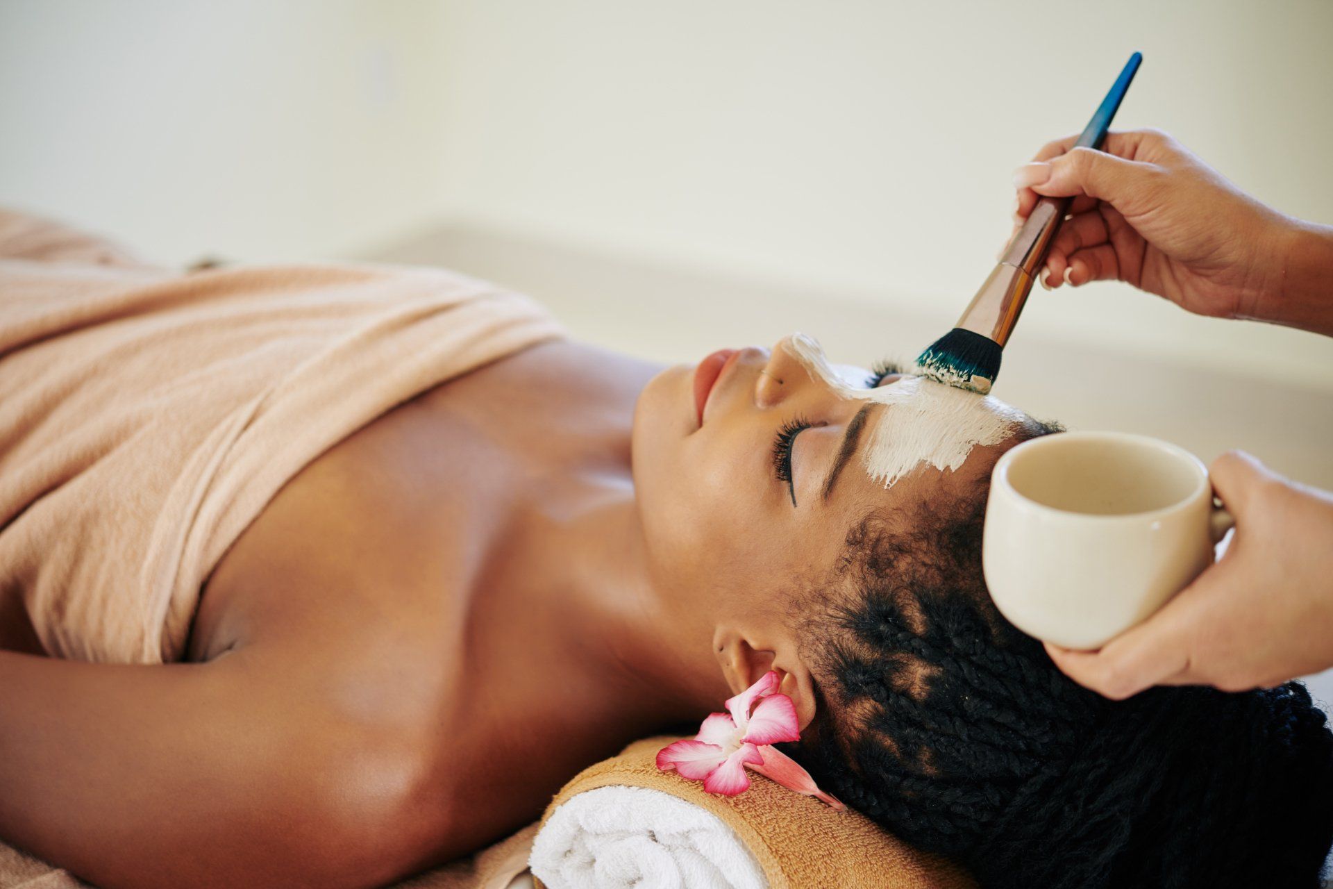 Una mujer está recibiendo un tratamiento facial en un spa.