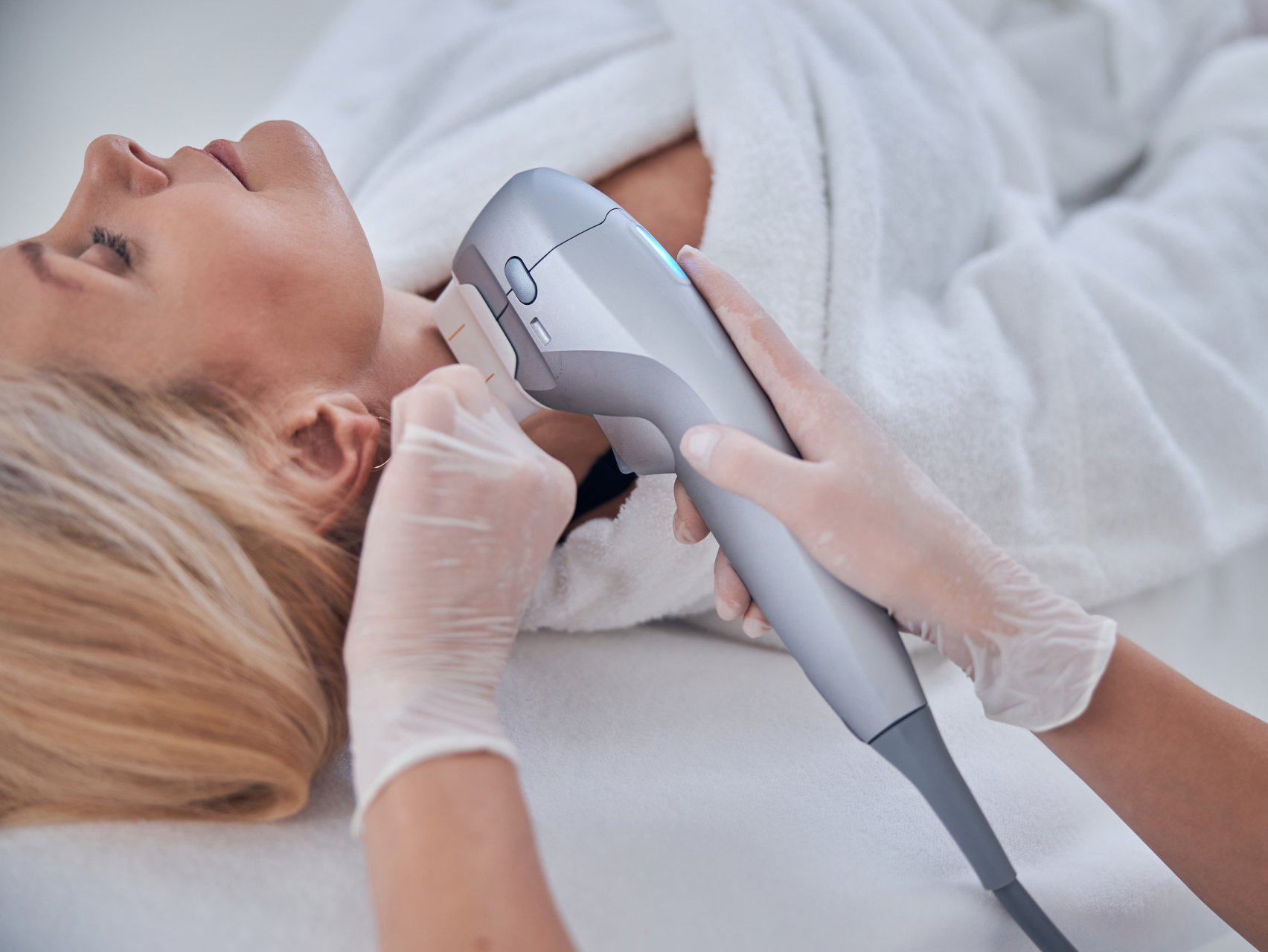 Una mujer está recibiendo un tratamiento con láser en el cuello.