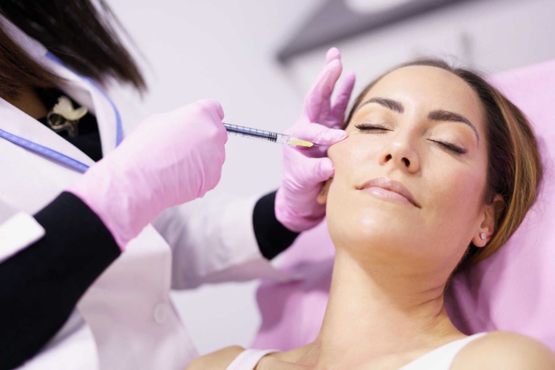 Una mujer recibe una inyección de botox en la cara.