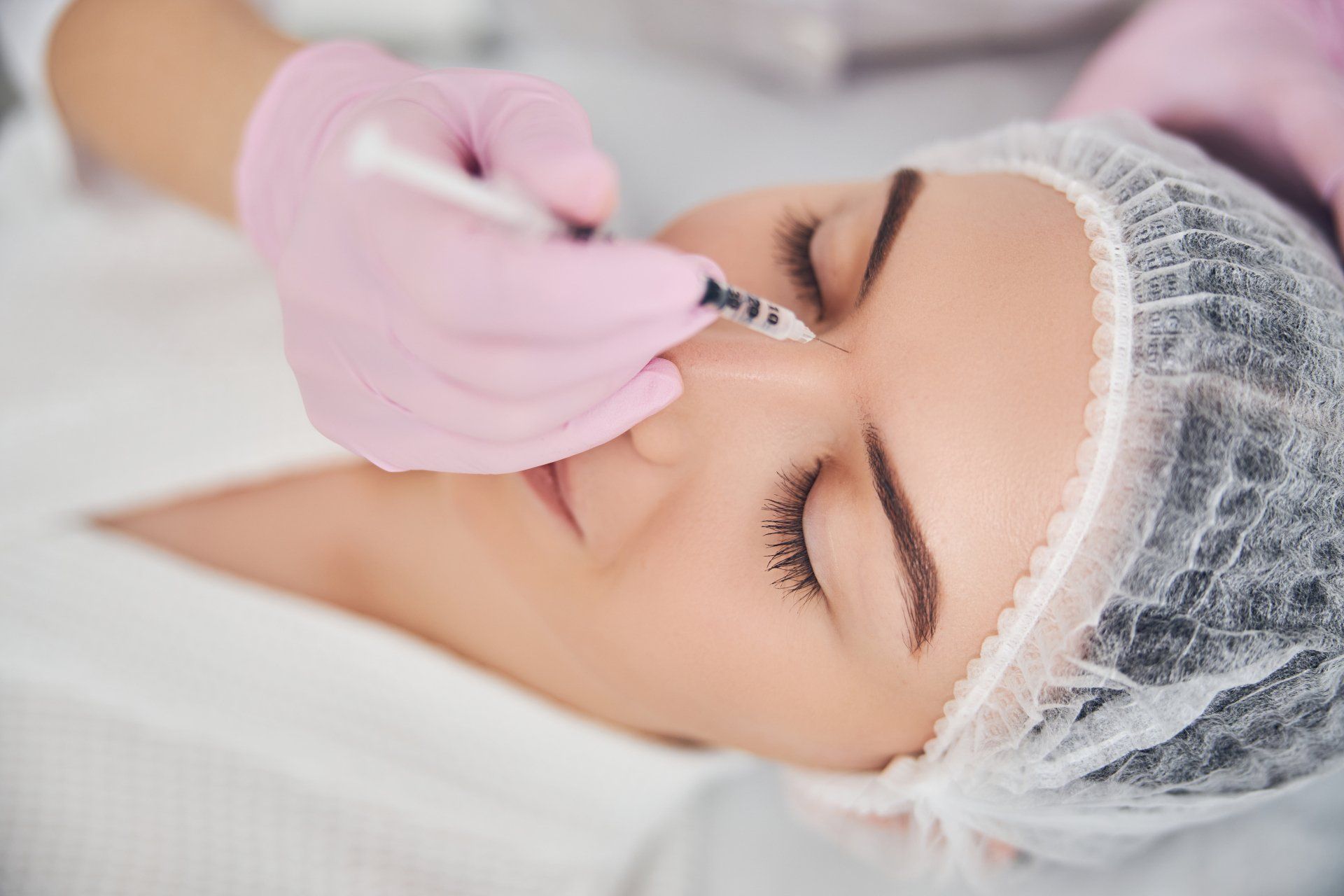 Una mujer recibe una inyección de botox en la cara.