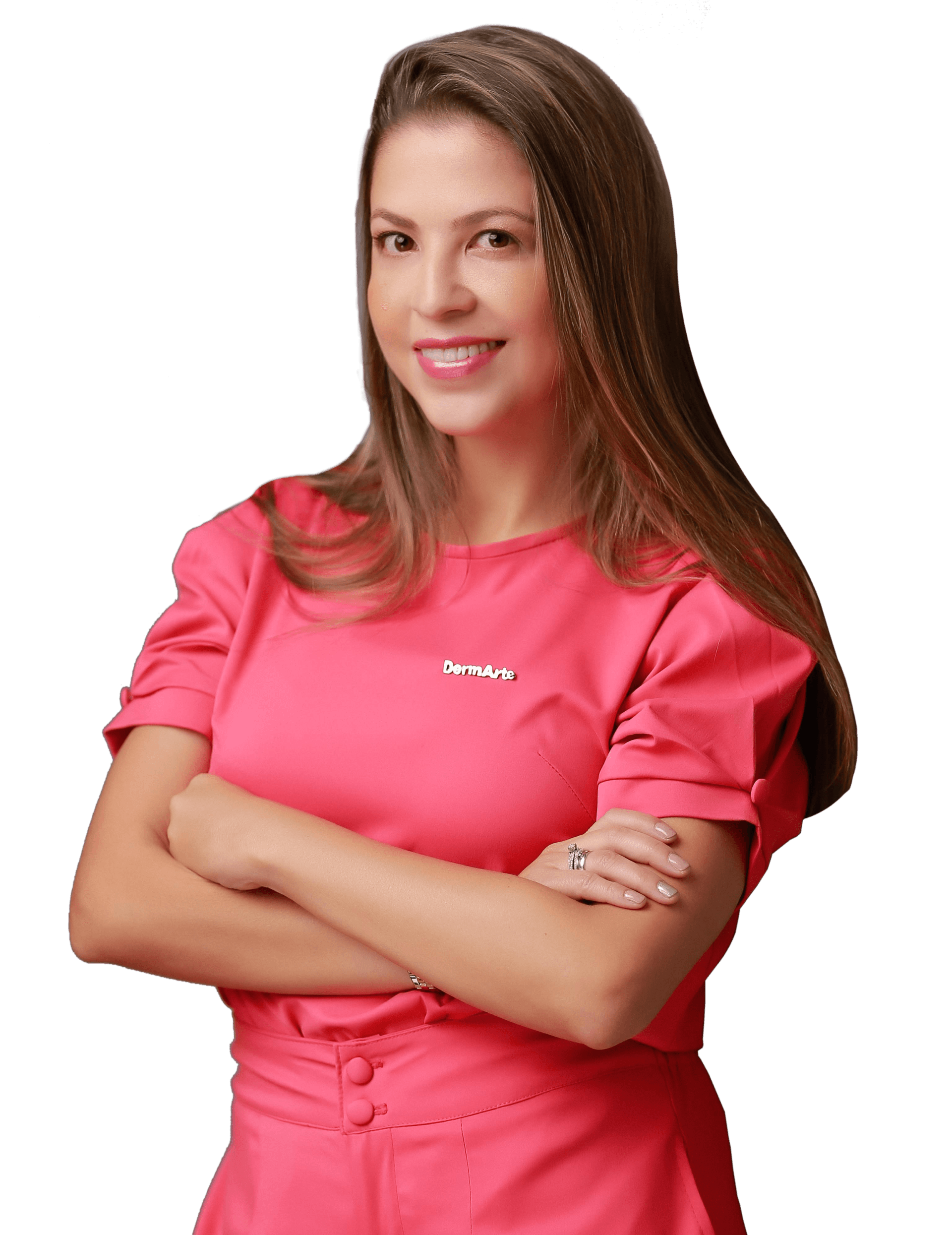 Una mujer con una camisa rosa está parada con los brazos cruzados y sonriendo.