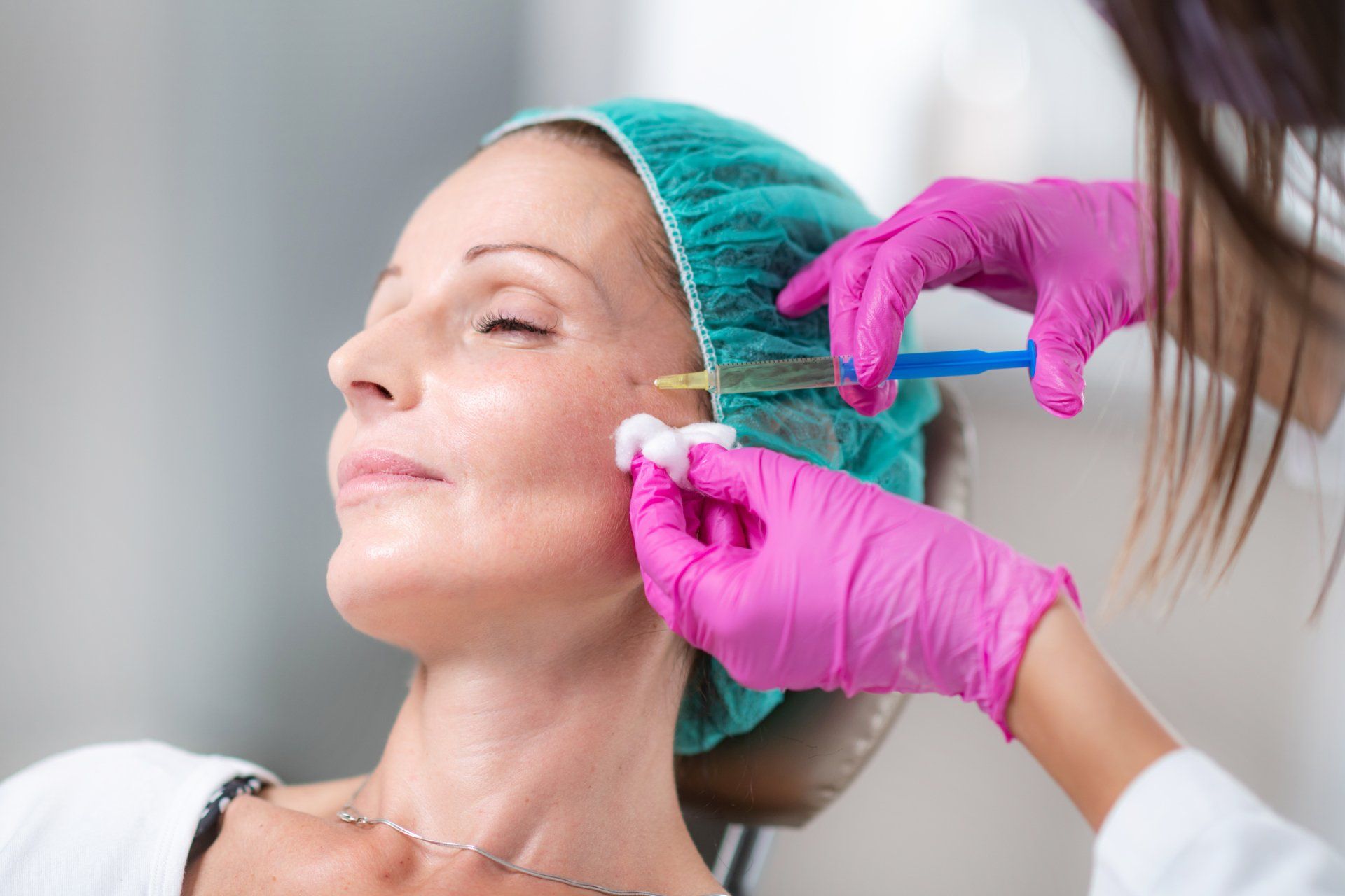 Una mujer recibe una inyección de botox en la cara.