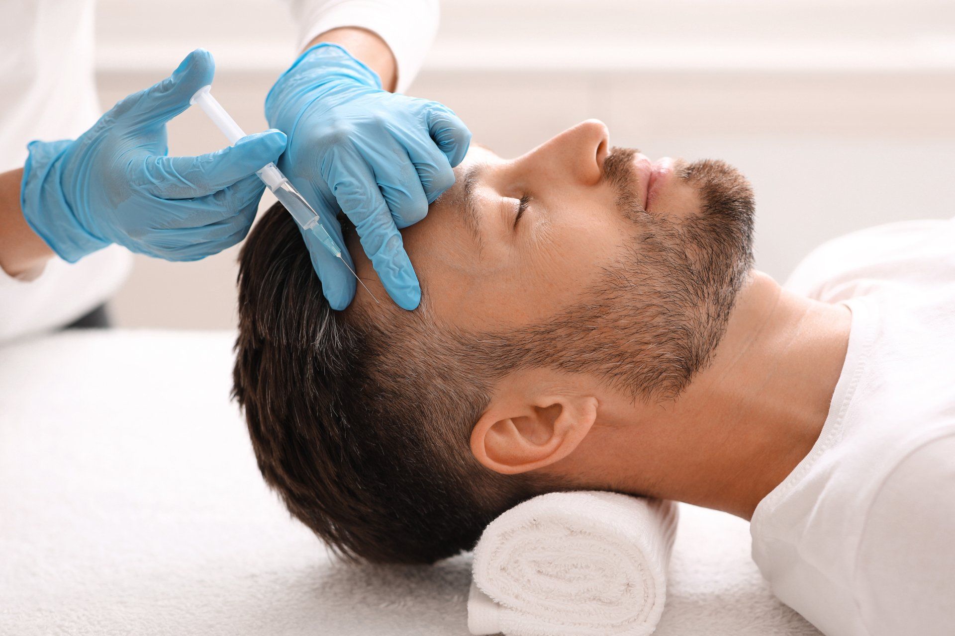 Un hombre recibe una inyección de botox en la frente.