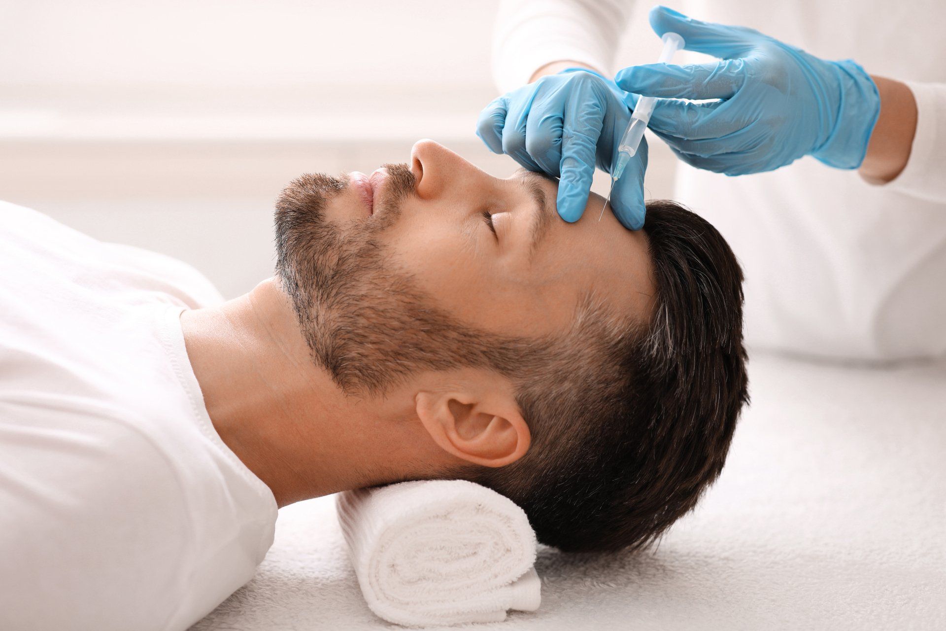 Un hombre recibe una inyección de botox en la frente.