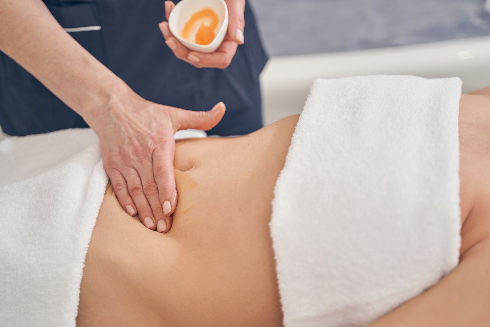 Una mujer está recibiendo un masaje en el estómago en un spa.