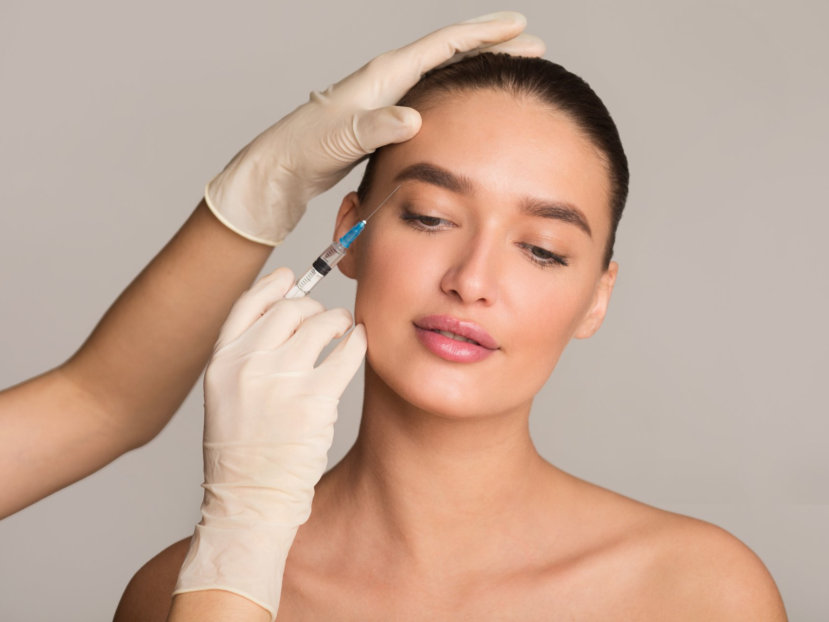 Una mujer recibe una inyección de botox en la frente.