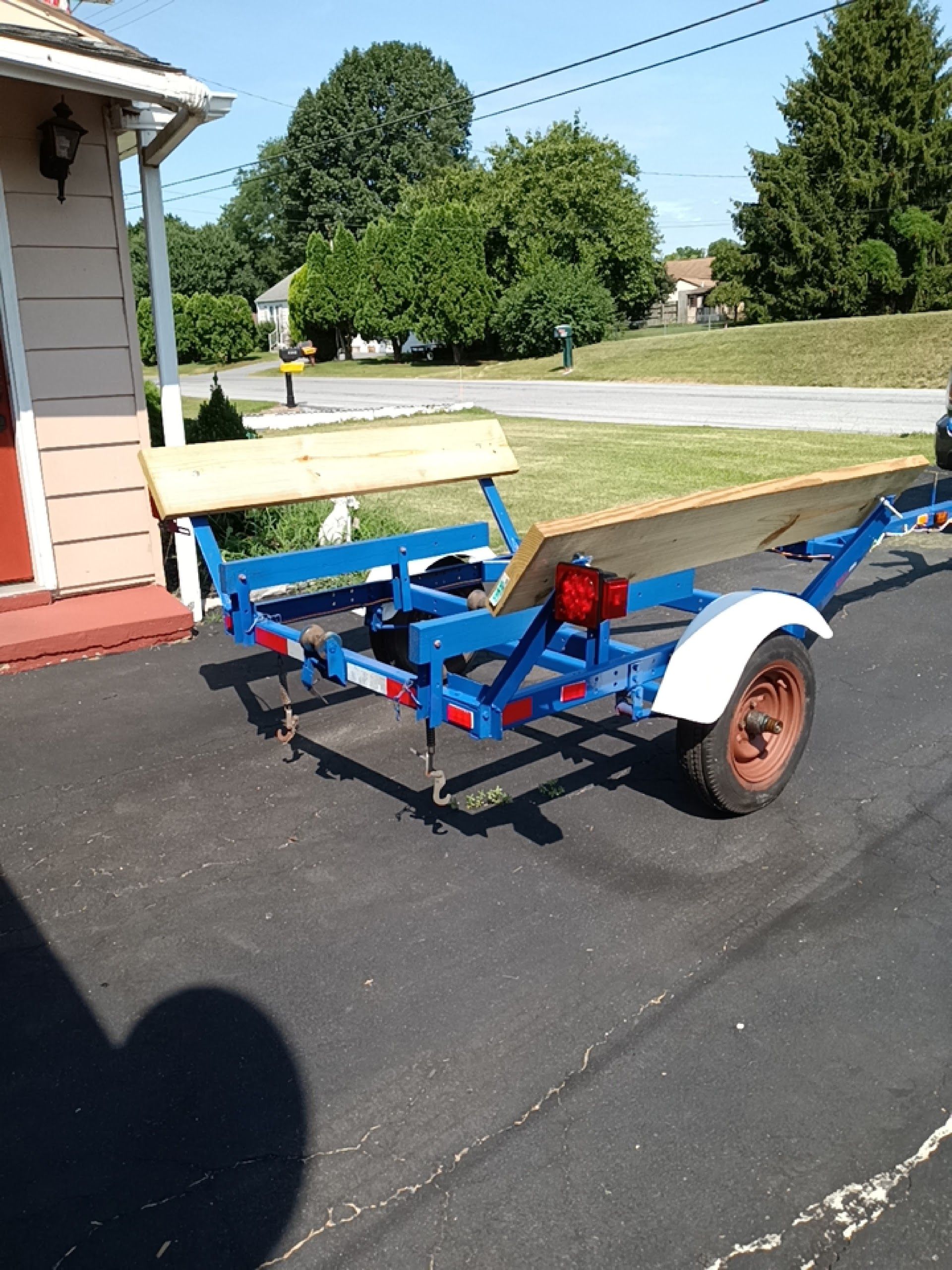Blue trailer with wooden benches in a driveway | Central Auto Works