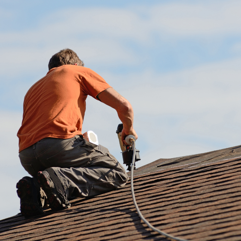 A man installing a shingle roof.