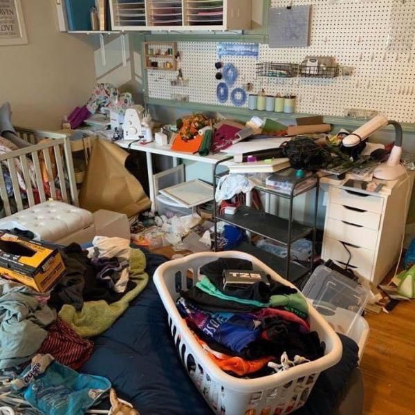 Messy room with laundry basket, desk, and various items scattered around.