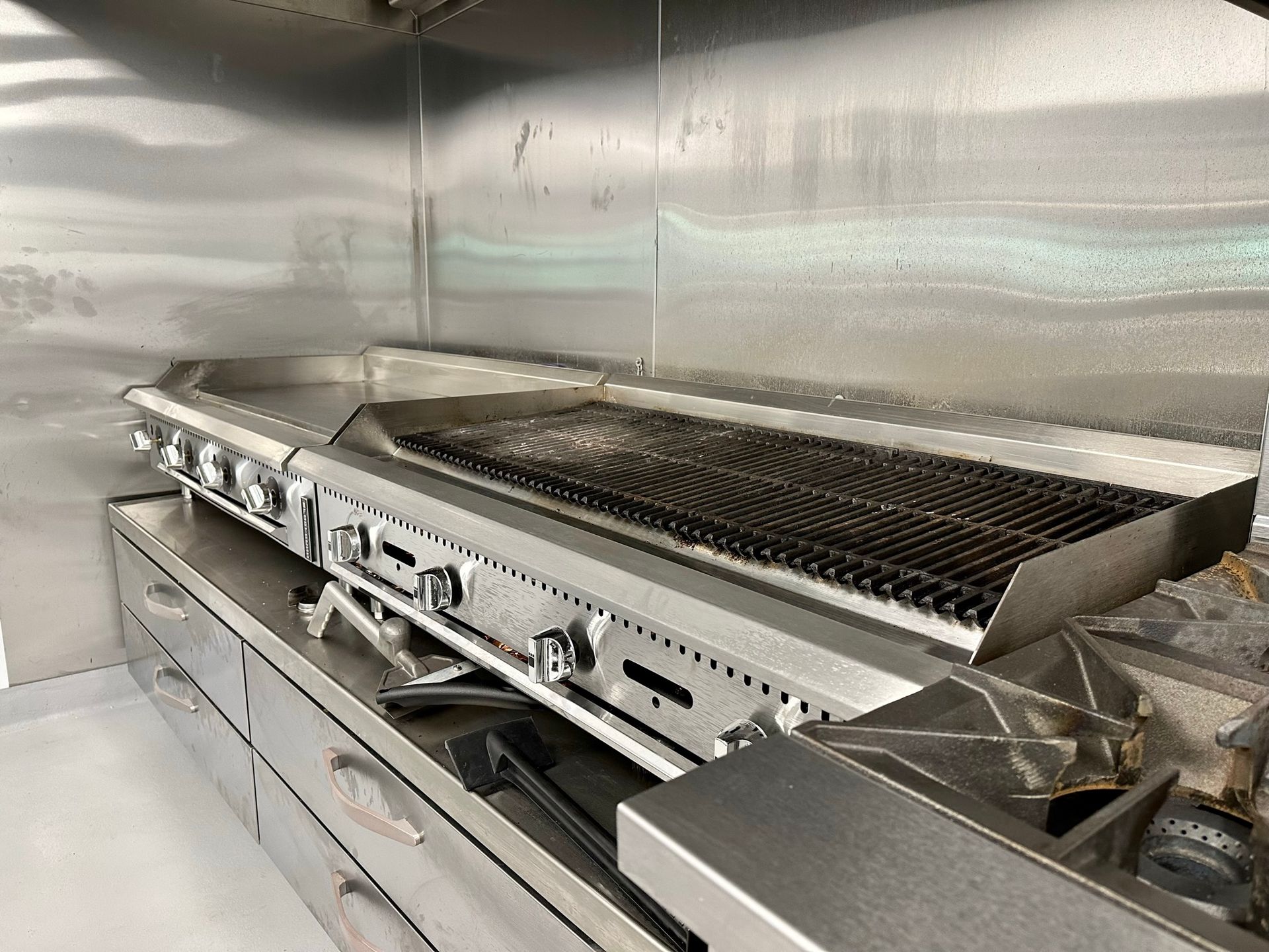 A stainless steel grill is sitting on top of a stove in a kitchen.