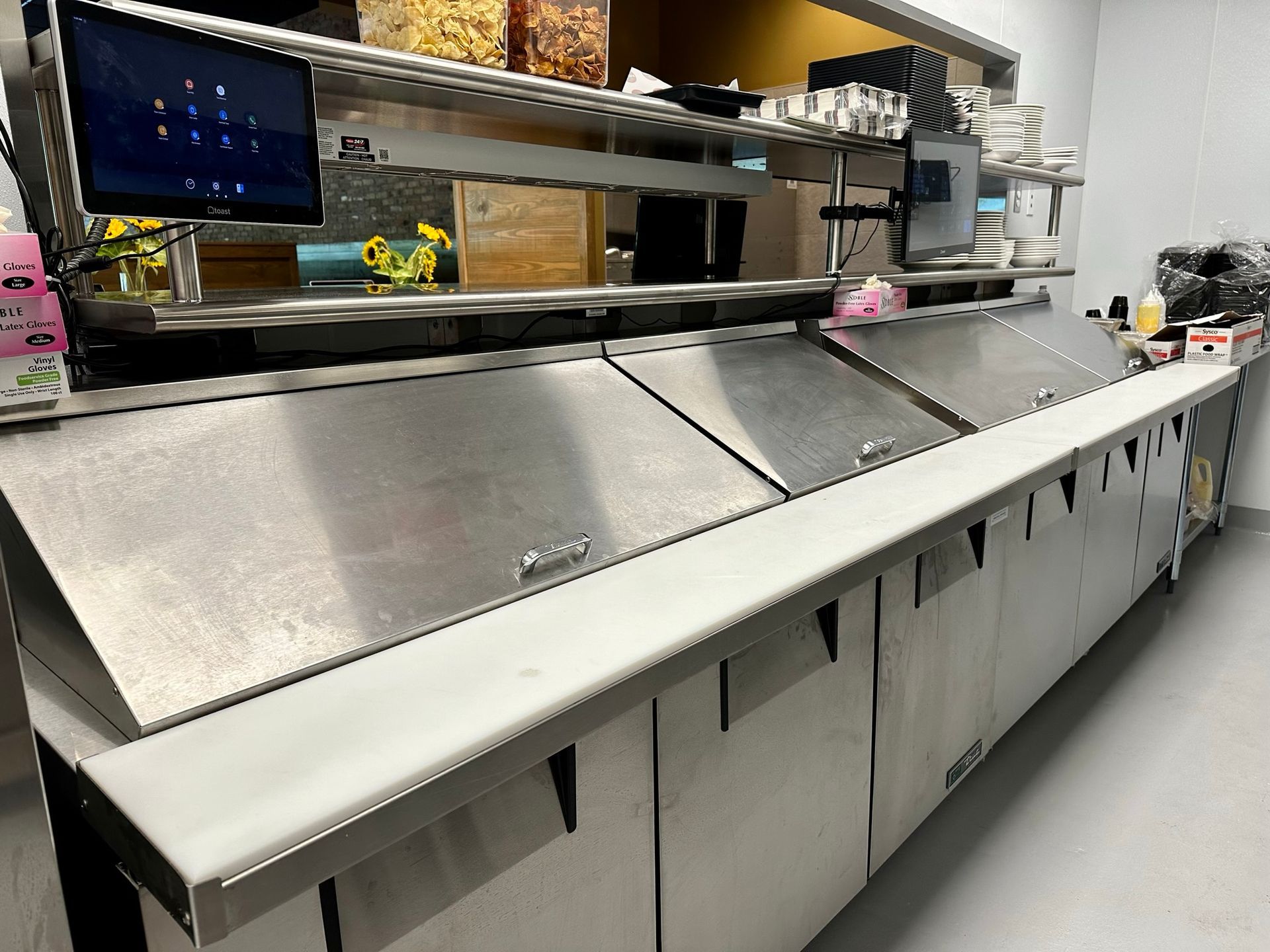 A long stainless steel counter in a restaurant kitchen