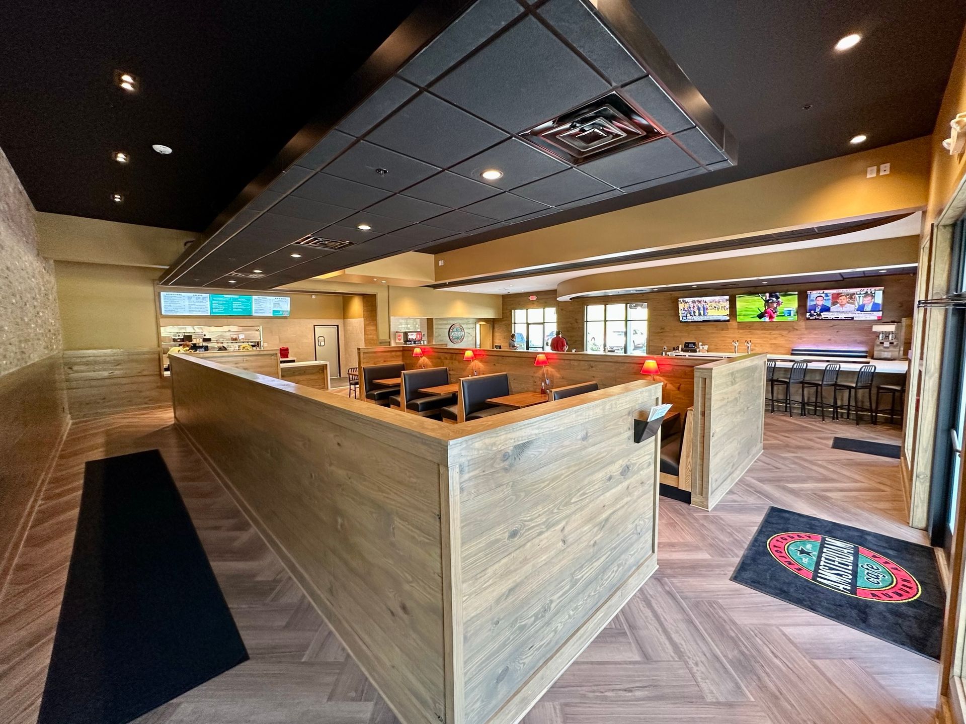 The inside of a restaurant with wooden tables and chairs.