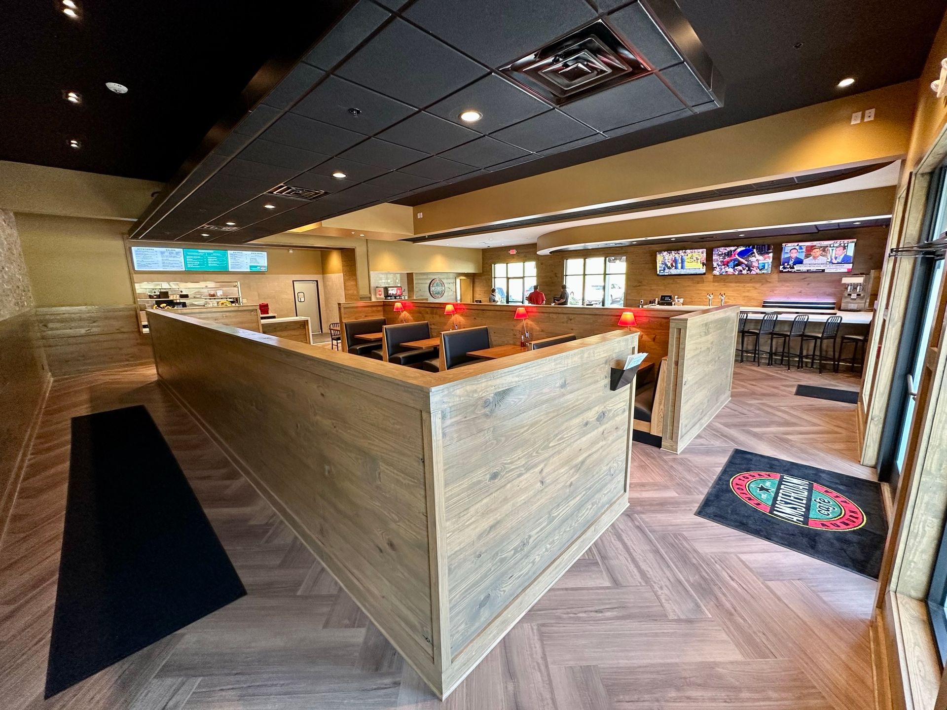 The inside of a restaurant with wooden tables and chairs.