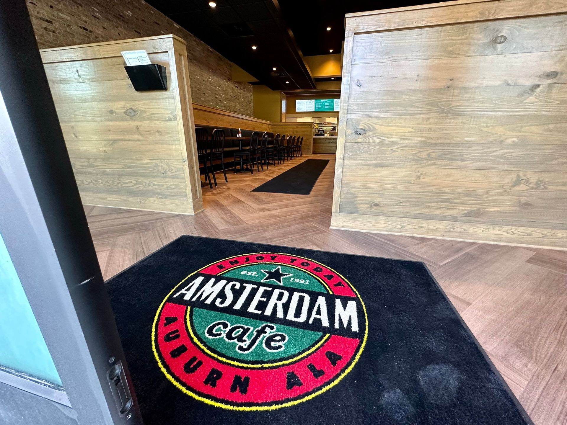 A black mat with the amsterdam cafe logo on it