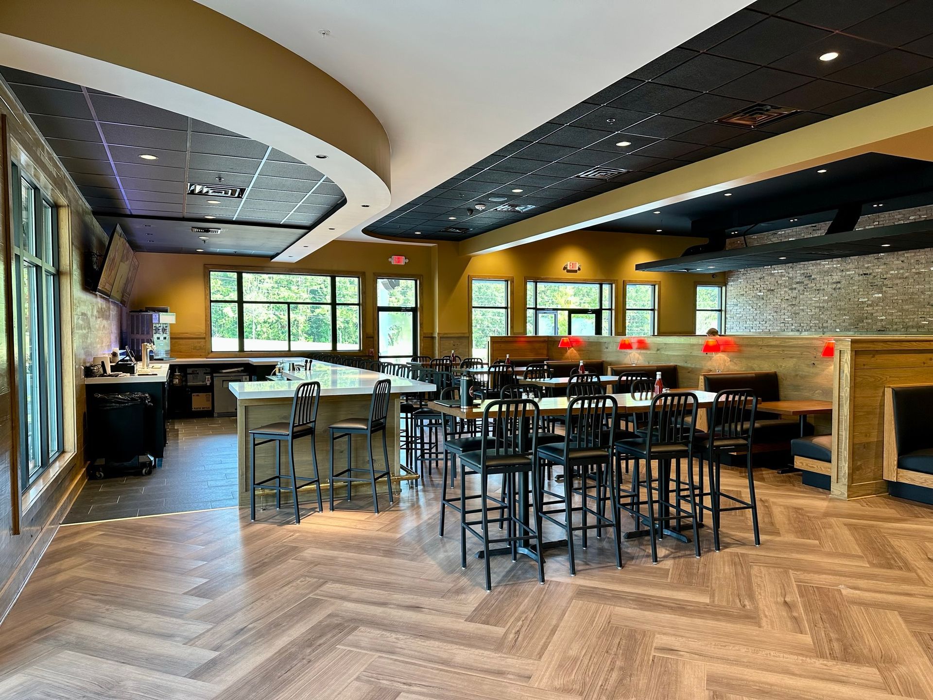 A restaurant with tables and chairs and a herringbone floor.