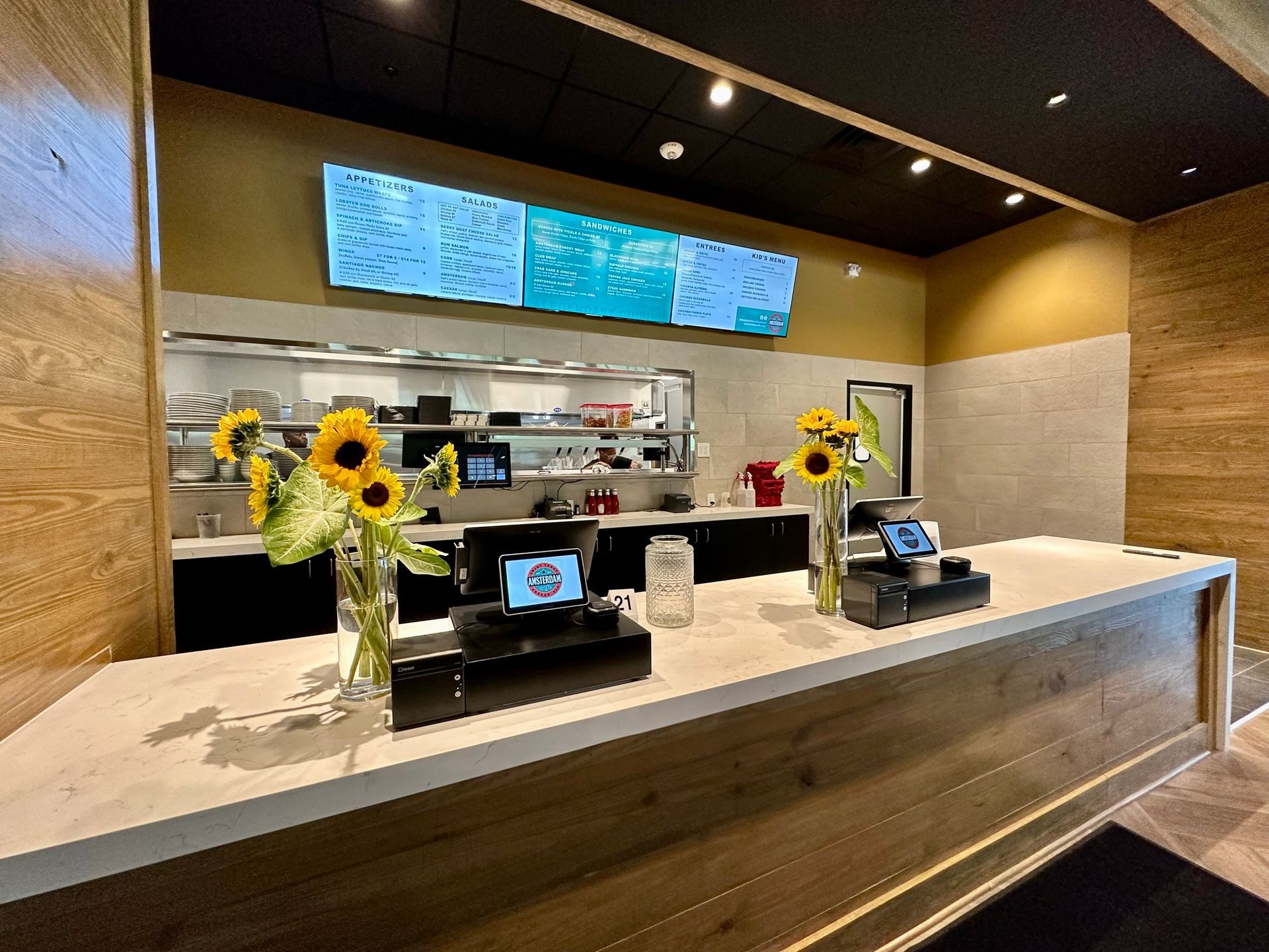 A restaurant with a counter and flowers on it.