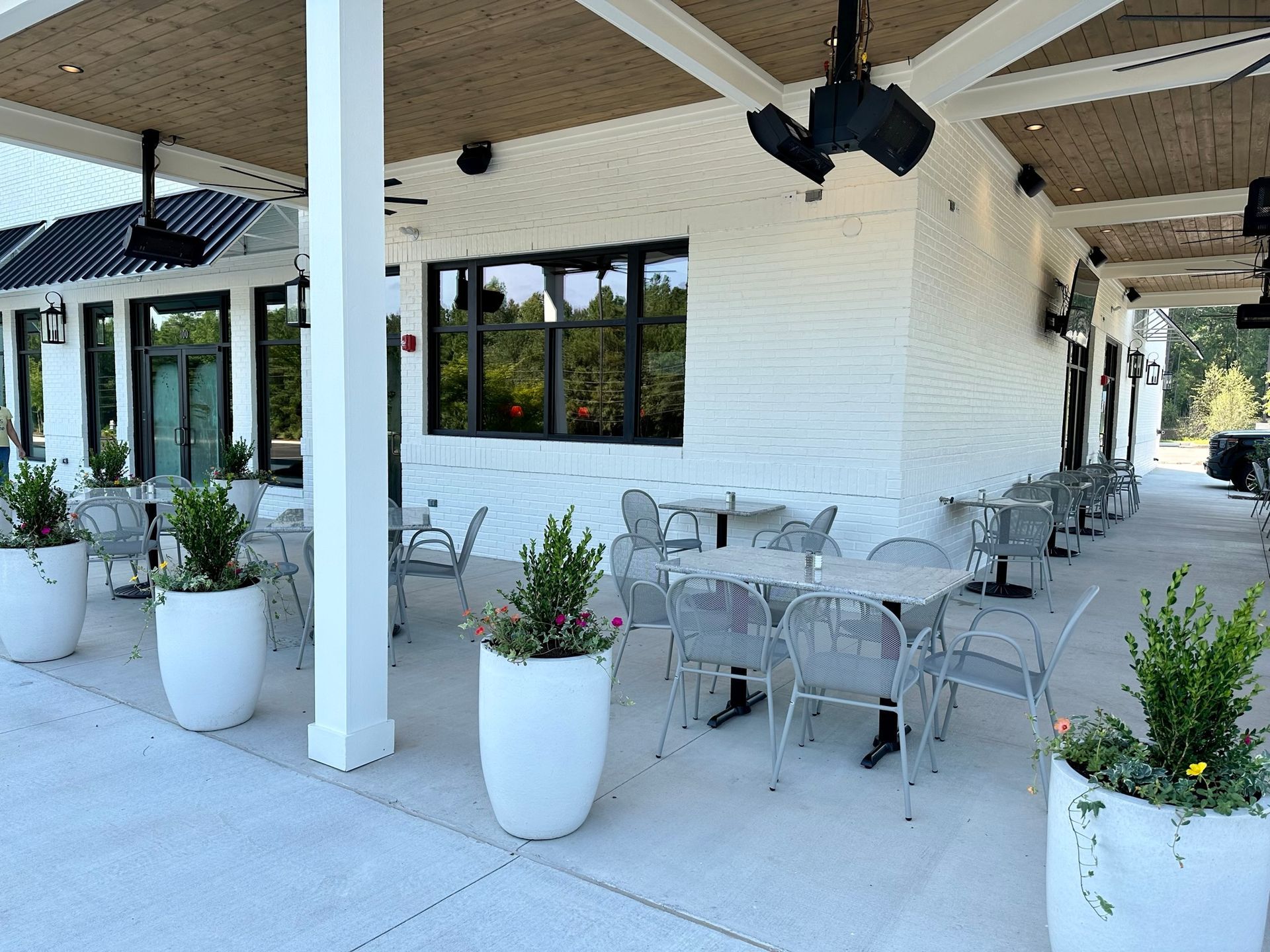A patio area with tables and chairs under a canopy.