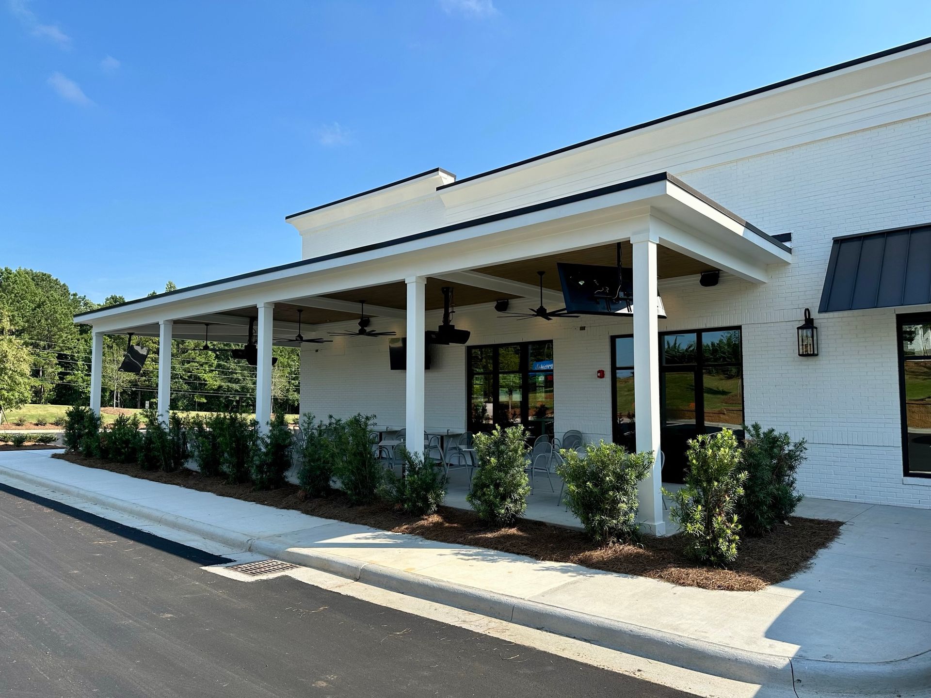 A white building with a porch and a blue sky in the background