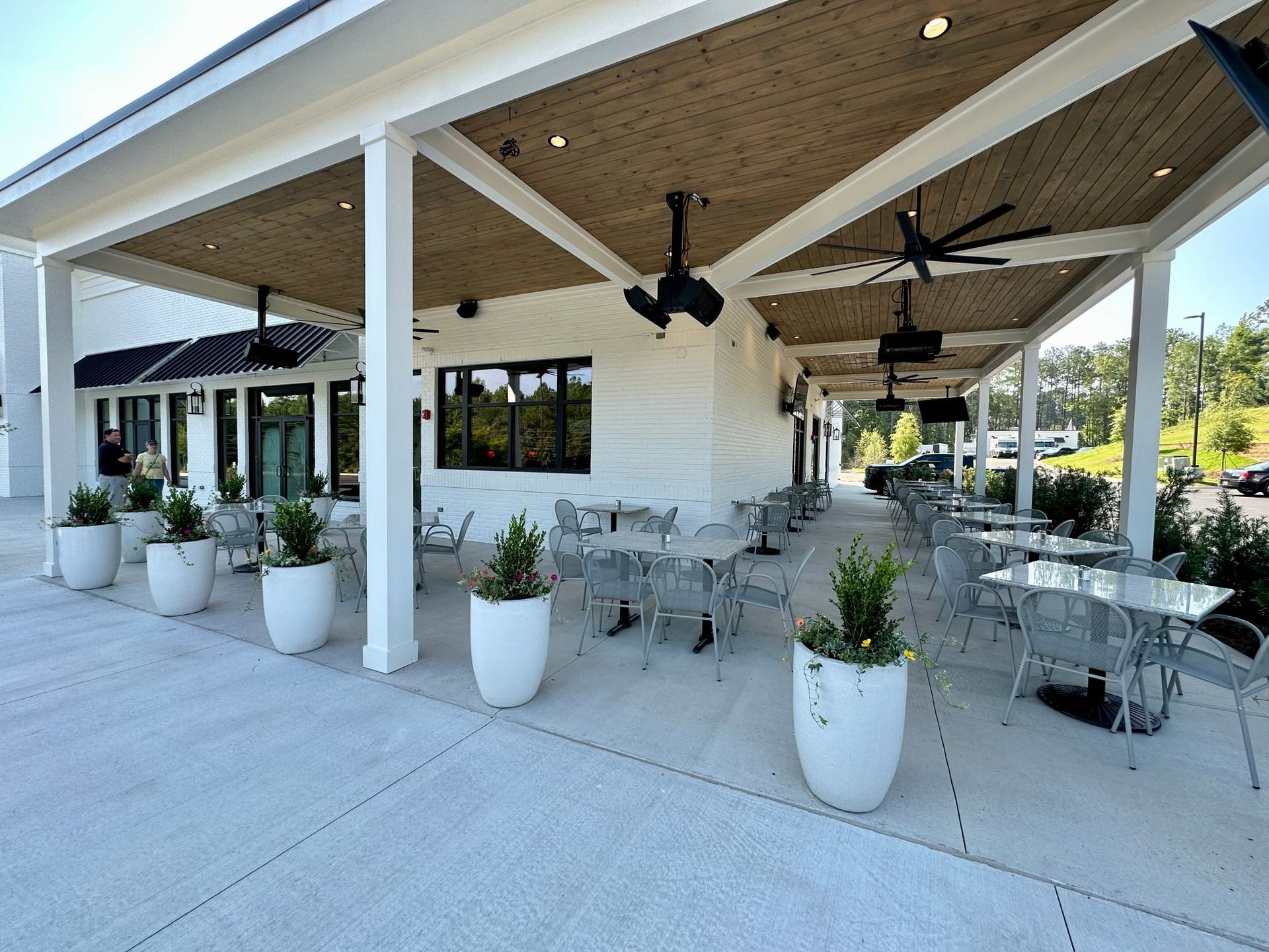 A restaurant with tables and chairs under a canopy.