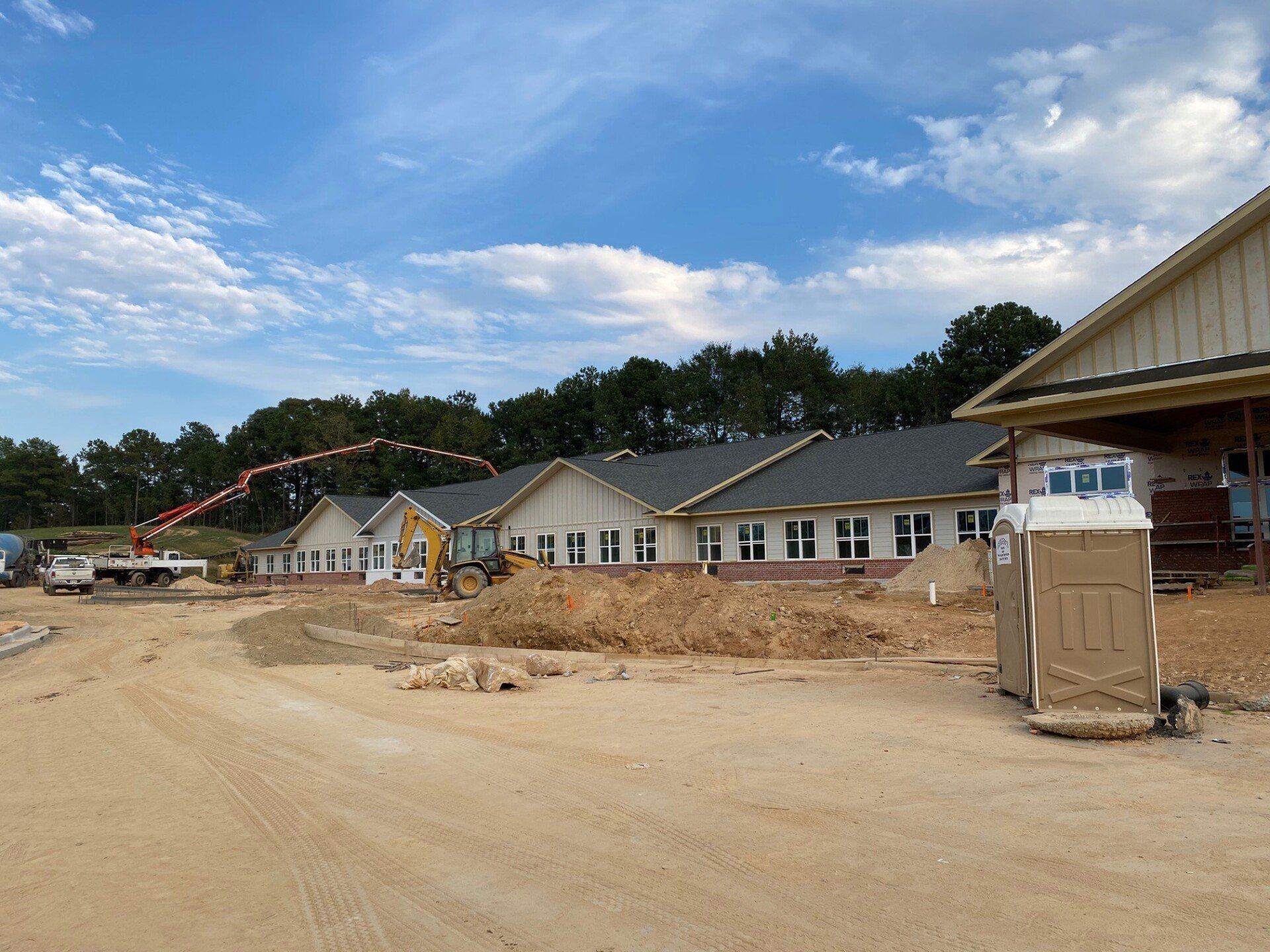 A row of houses are being built on a dirt road.