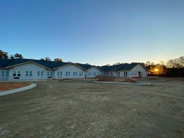 A large white building with a blue roof is being built.