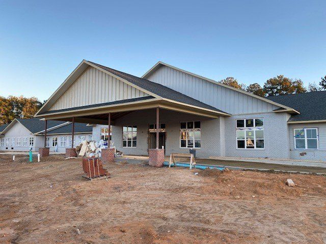 A white building with a black roof is under construction