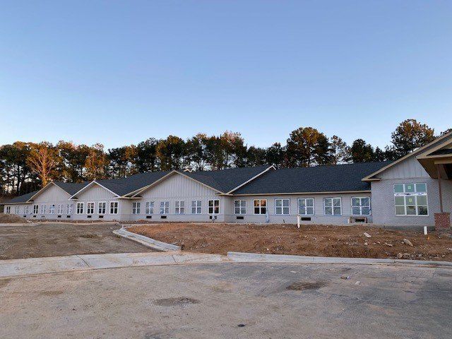 A large white building with a black roof and a lot of windows