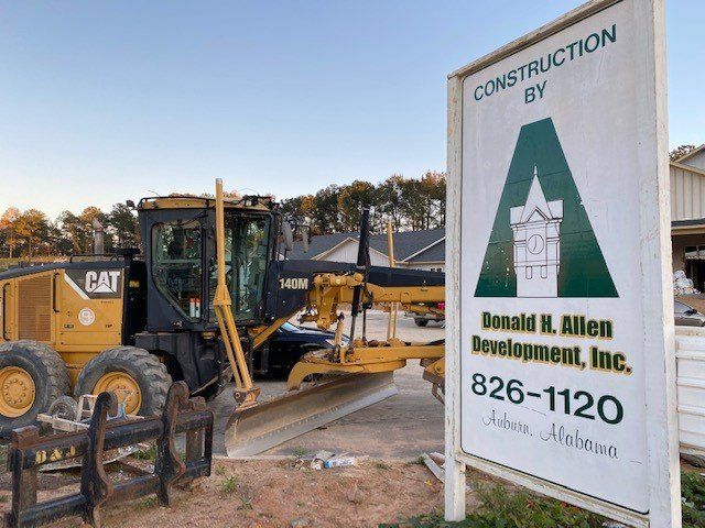 Commercial construction equipment beside a genera; contractor's sign