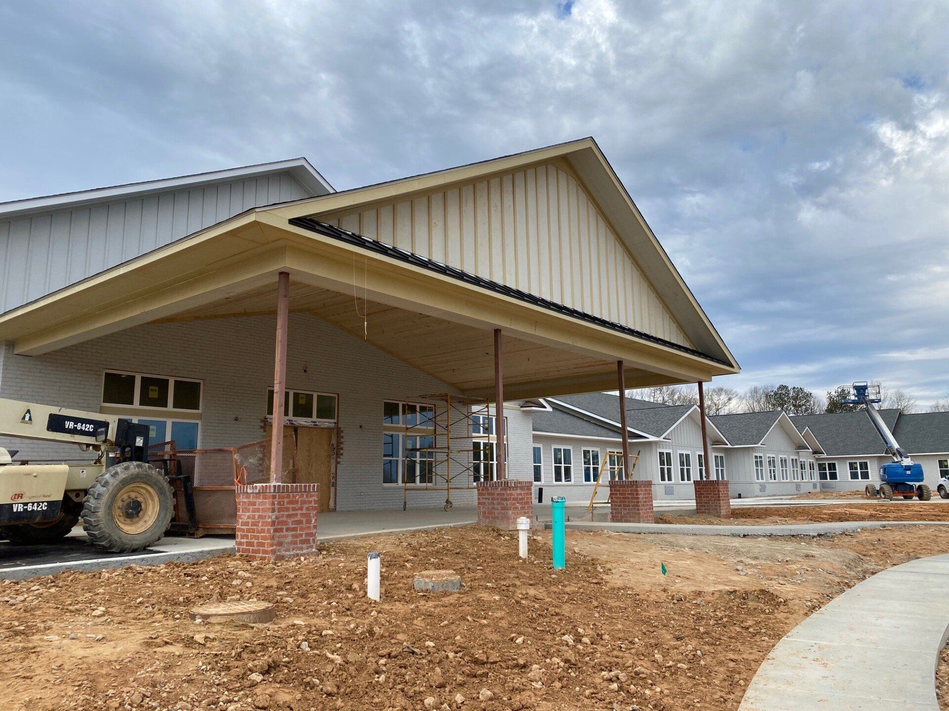 A tractor is parked in front of a building under construction.