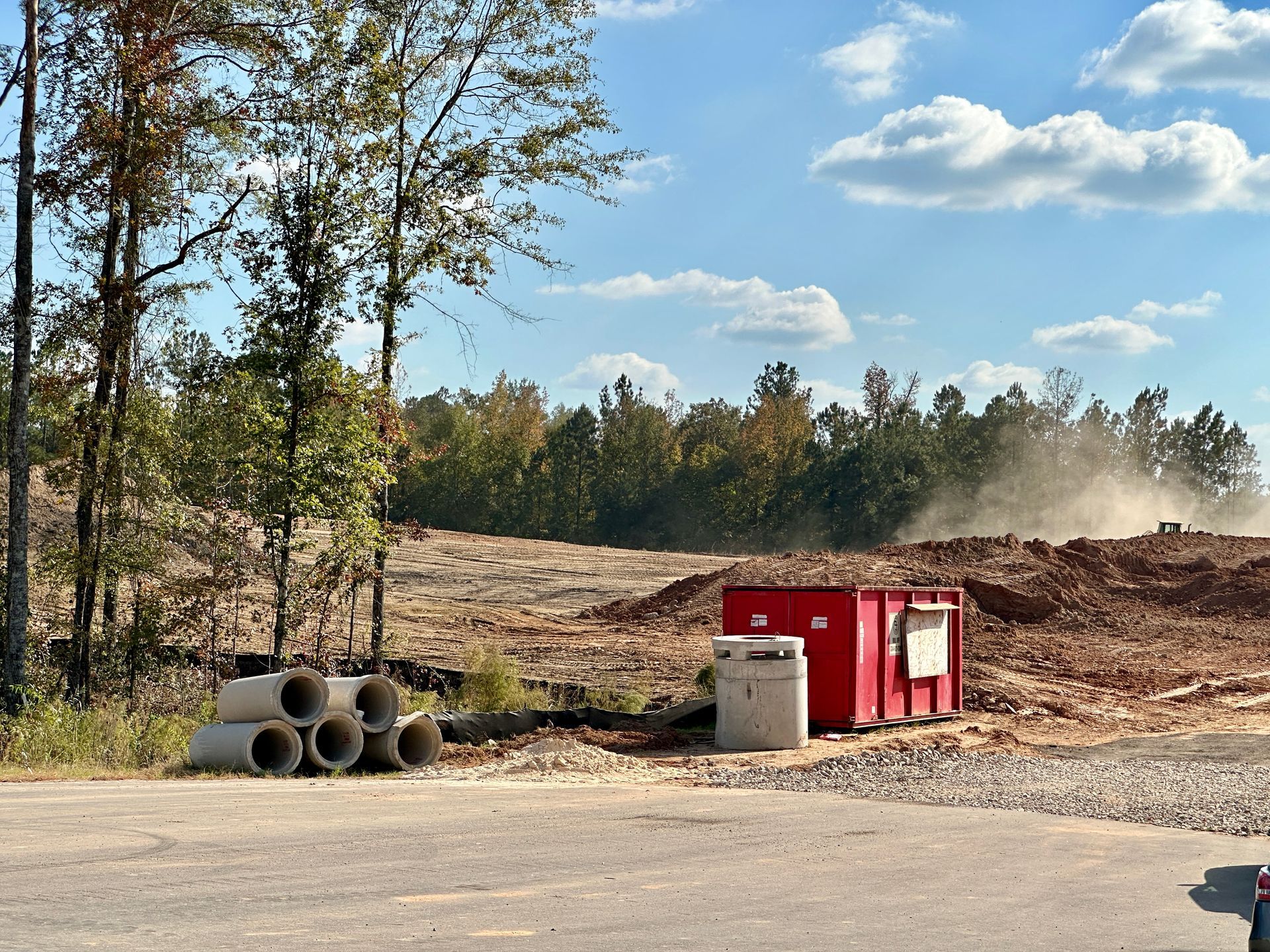 A red container sits in the middle of a dirt field