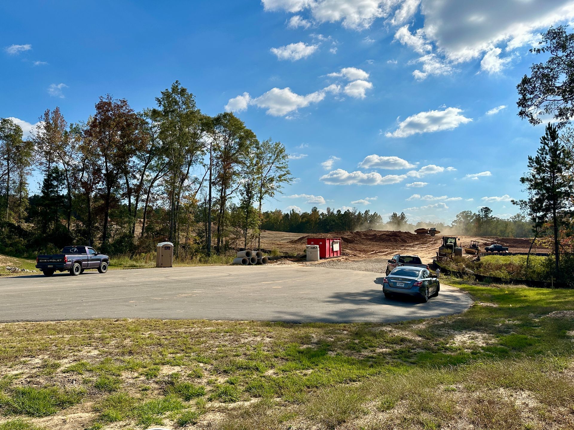 A car is parked in a parking lot next to a construction site.