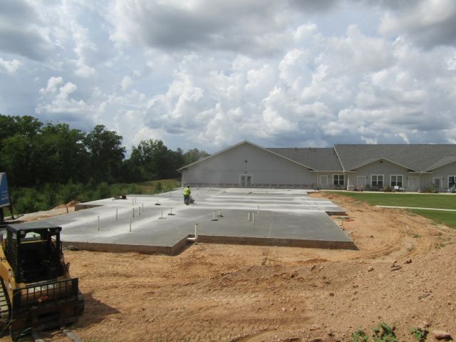 A concrete foundation is being built in front of a house