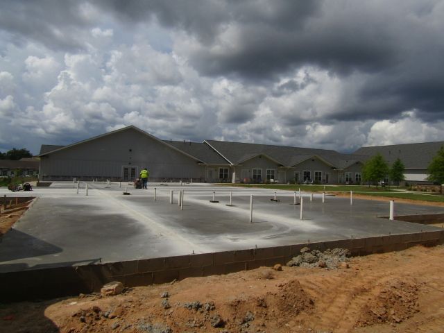 A large building under construction with a lot of clouds in the sky