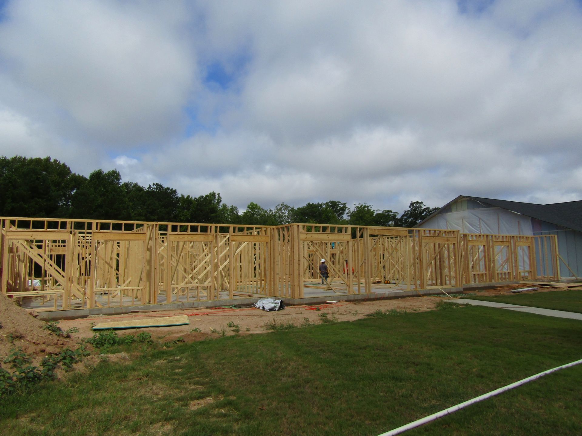 A large wooden structure is being built on a lush green field.