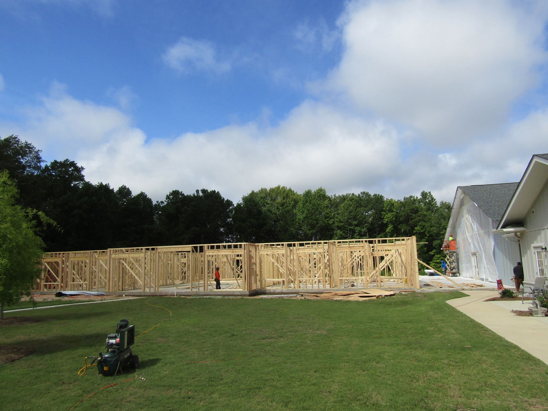 A building is being built on a lush green lawn