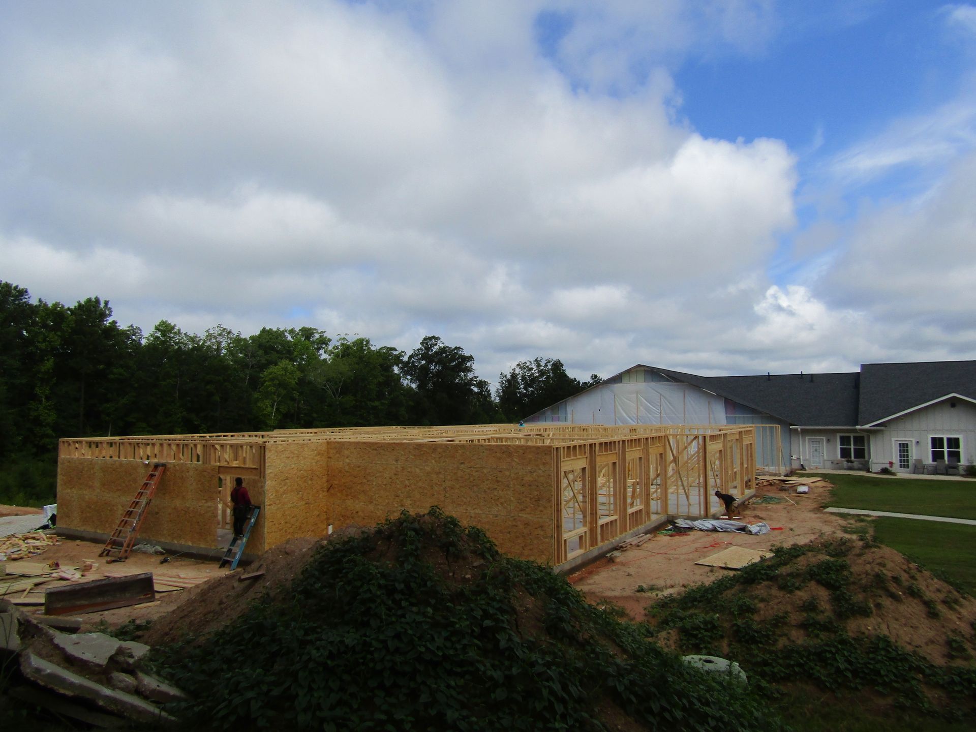 A large wooden structure is being built in front of a house.