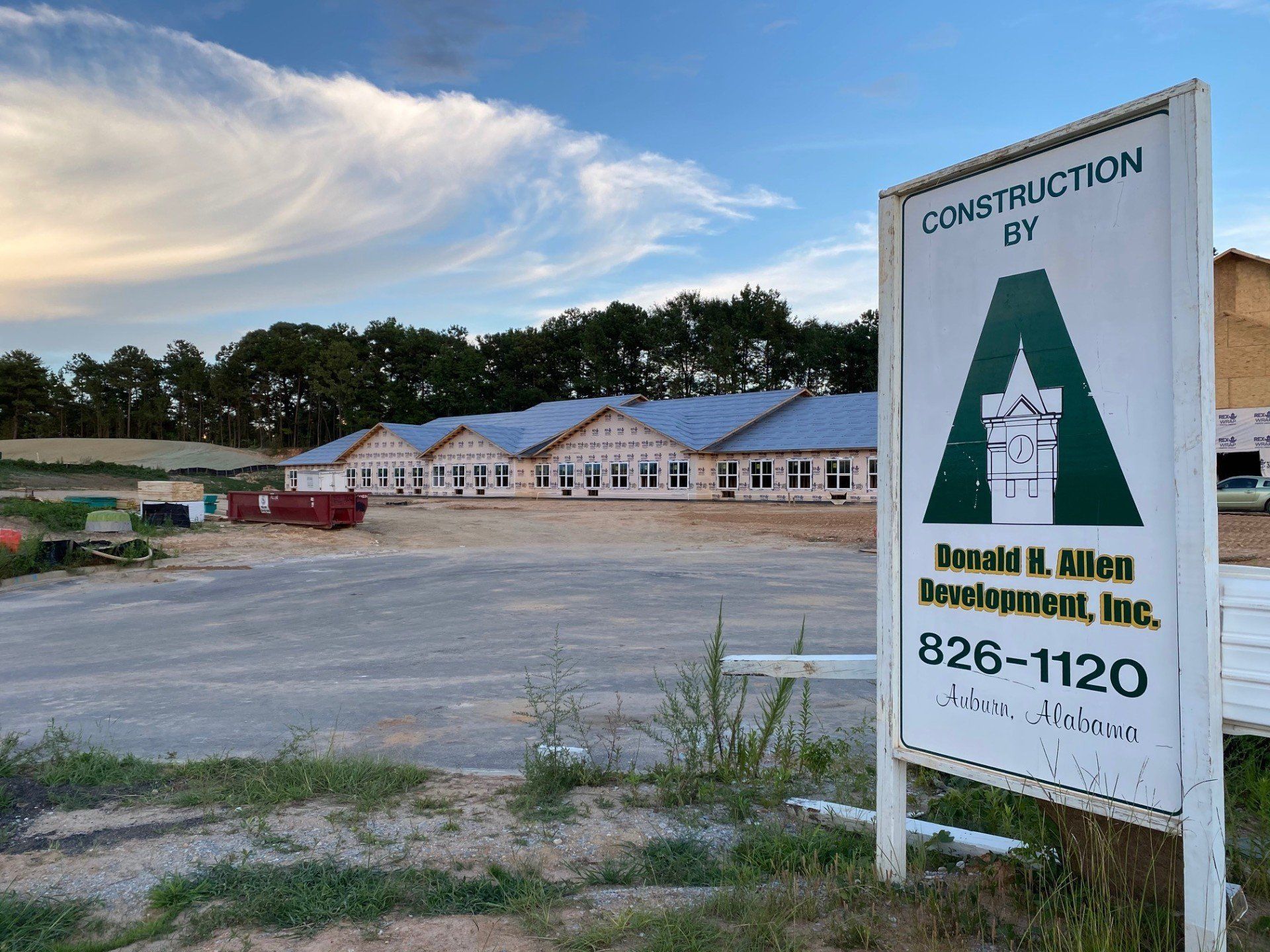 A construction sign is in front of a building under construction.