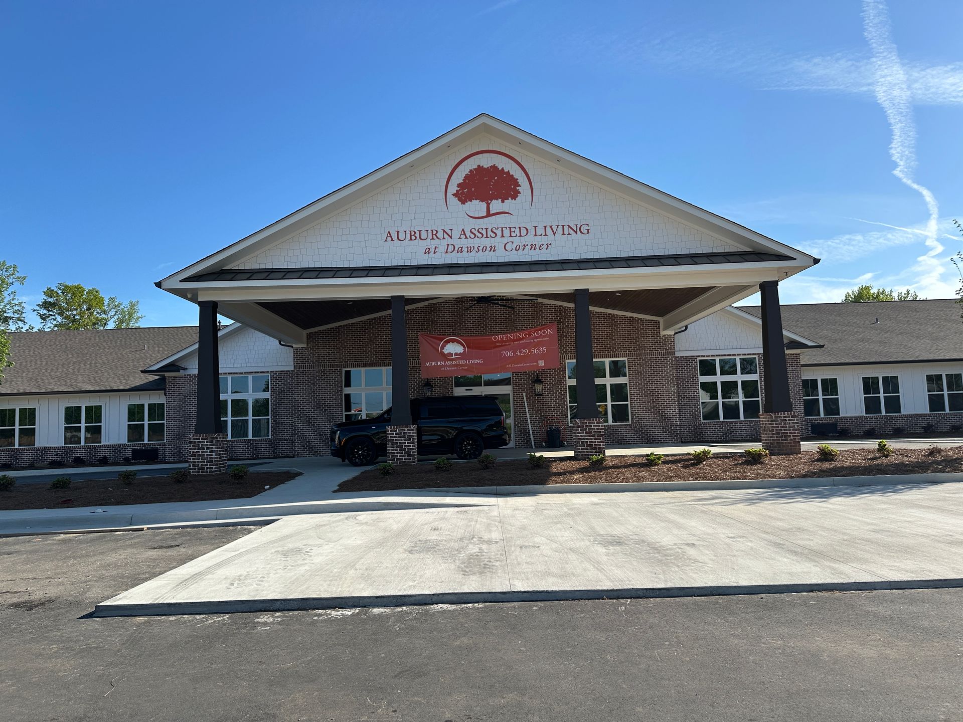 A single-story, white building with a large covered entrance and a sign reading 