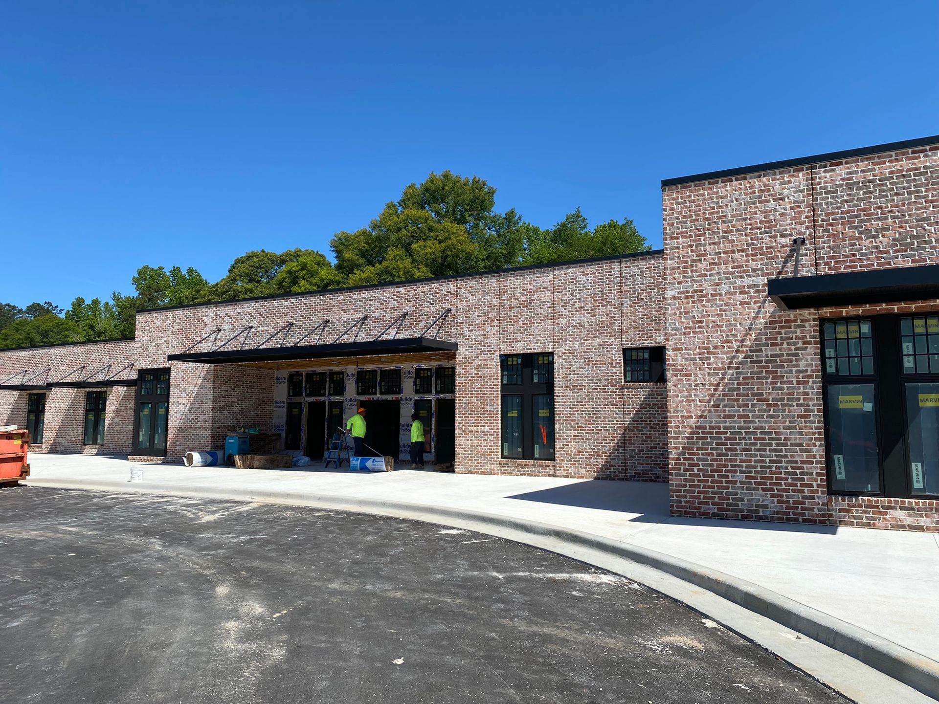 A row of brick buildings are being built on a sunny day.