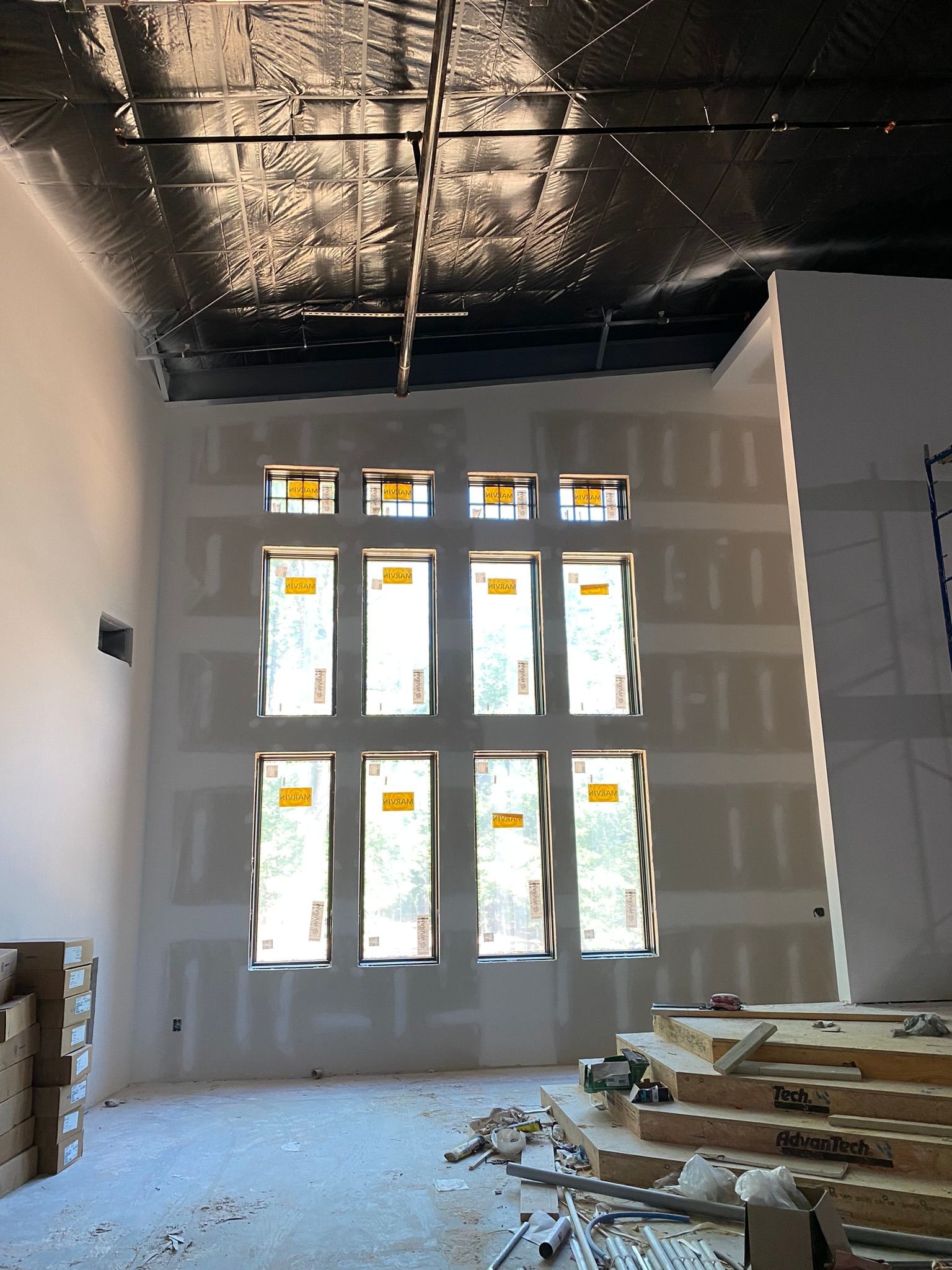 A room with a lot of windows and boxes on the floor.