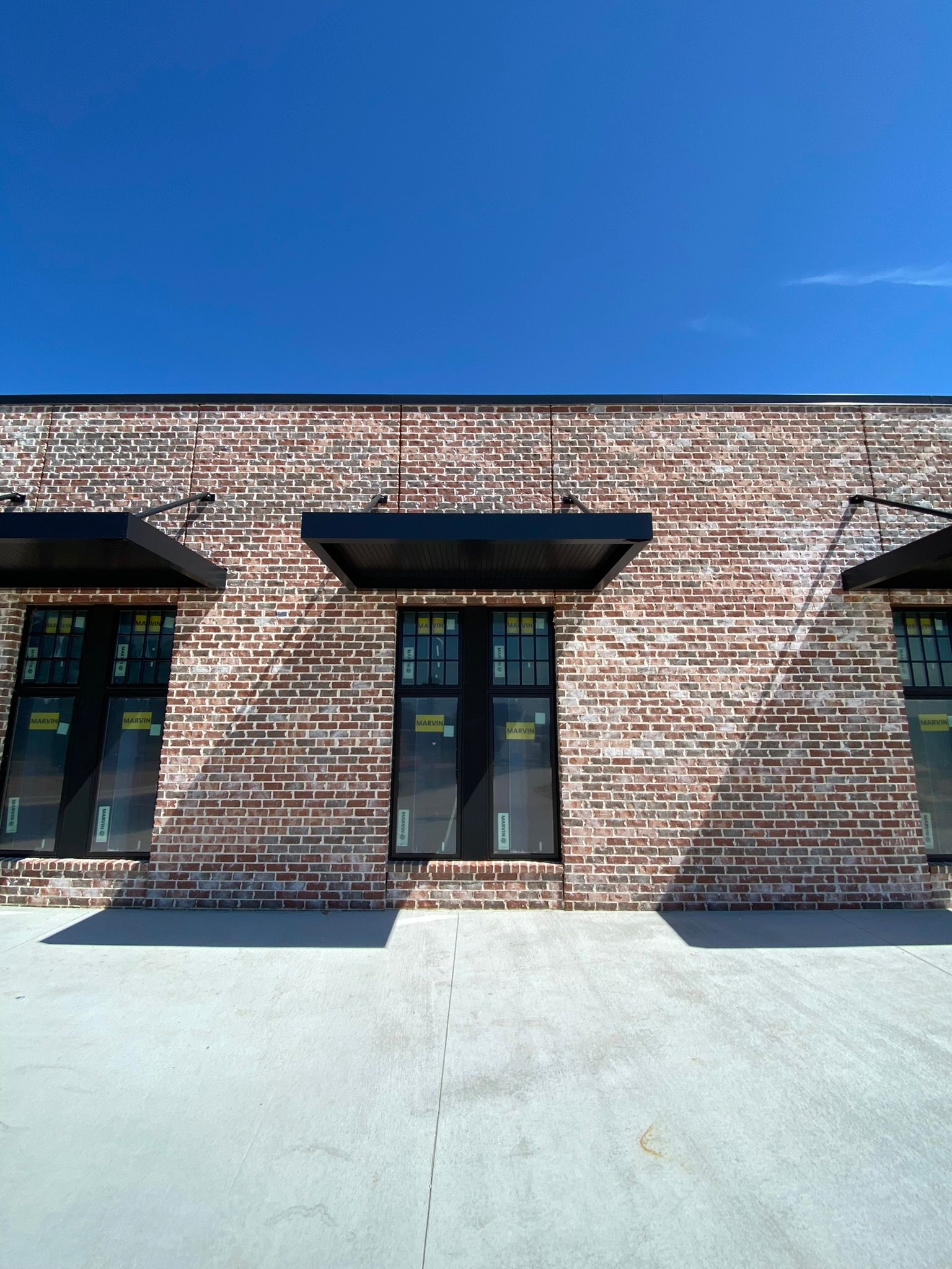 A brick building with a lot of windows and a blue sky in the background.