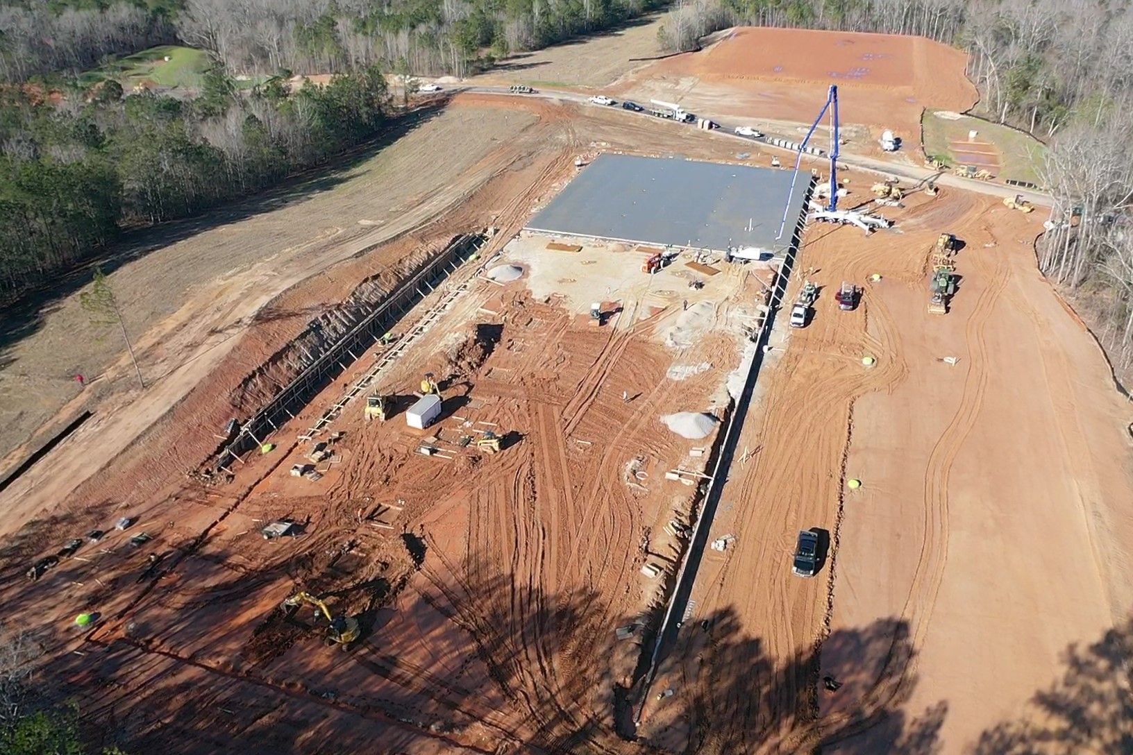 An aerial view of a construction site in the middle of a dirt road.