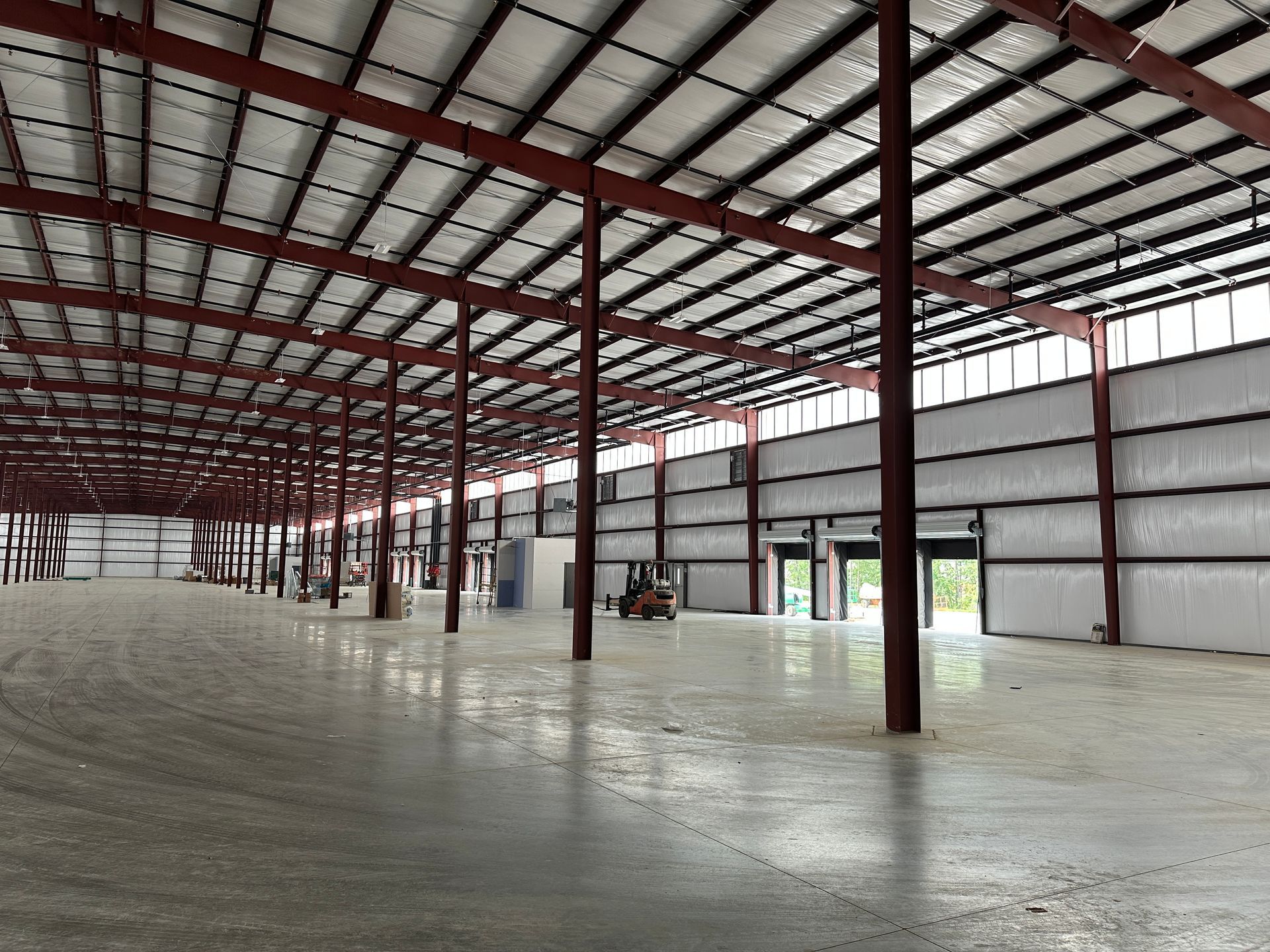 A large warehouse with a lot of windows and a concrete floor.