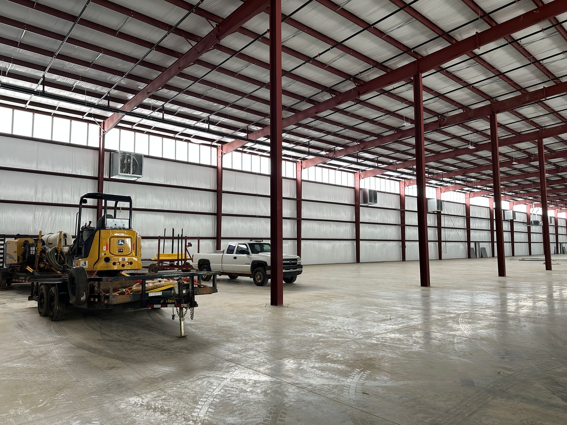 A large empty warehouse with a yellow truck parked in the middle
