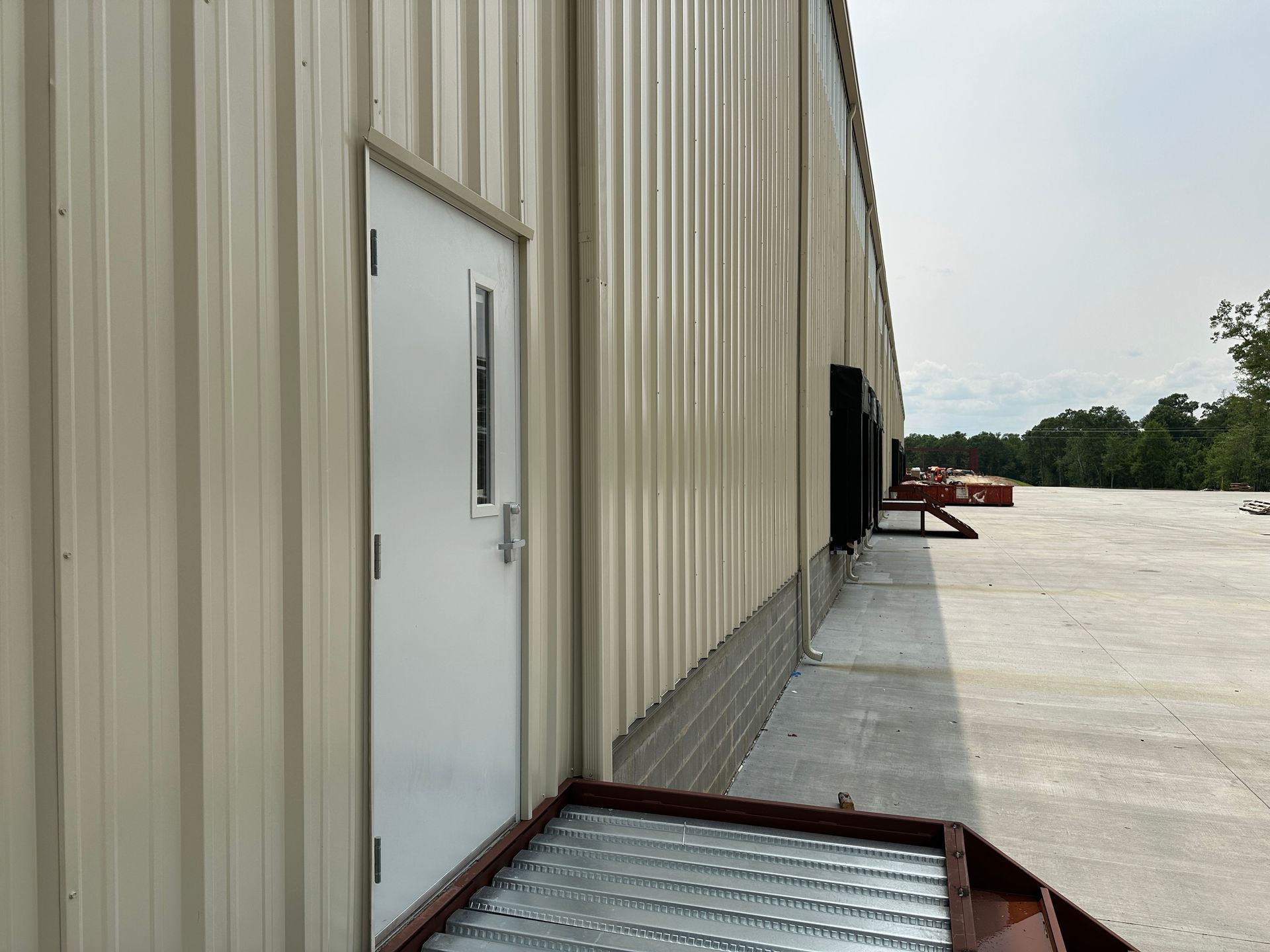 A white door is on the side of a building.