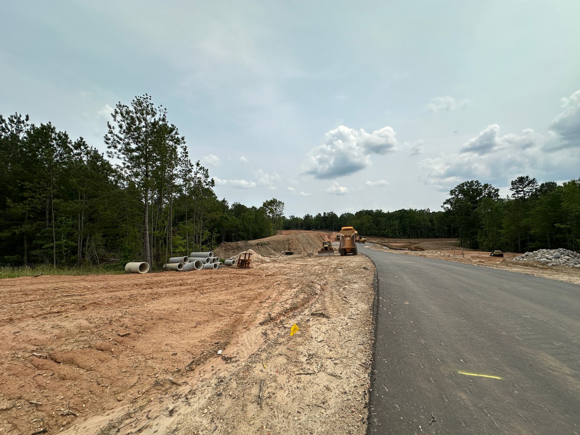 A road with a lot of dirt and trees on the side of it.