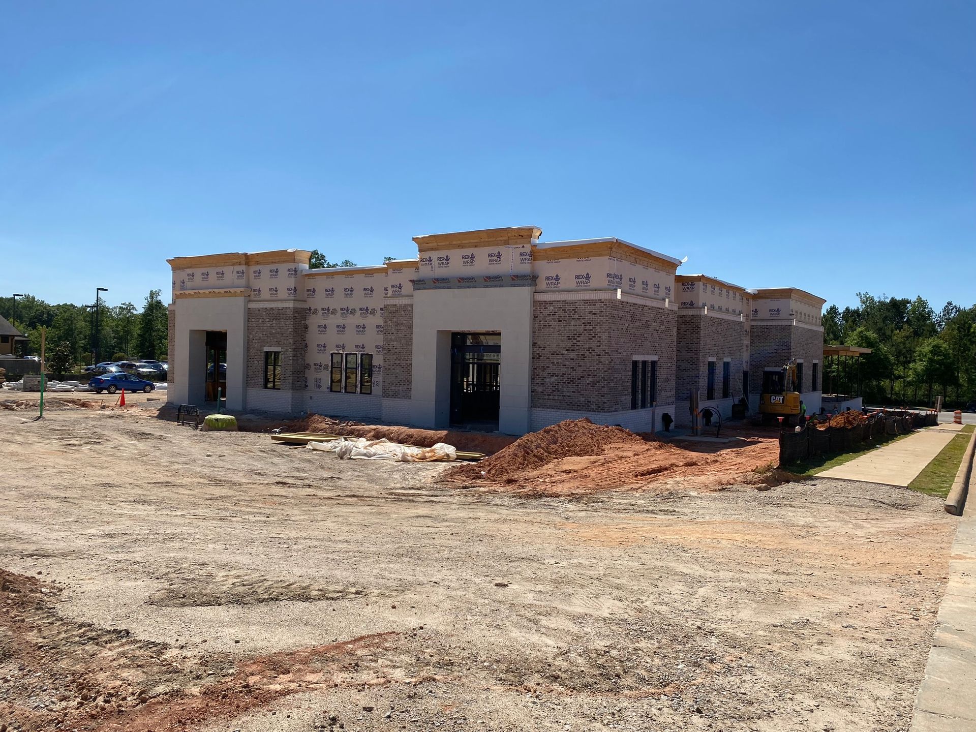 A large building is being built in a dirt field
