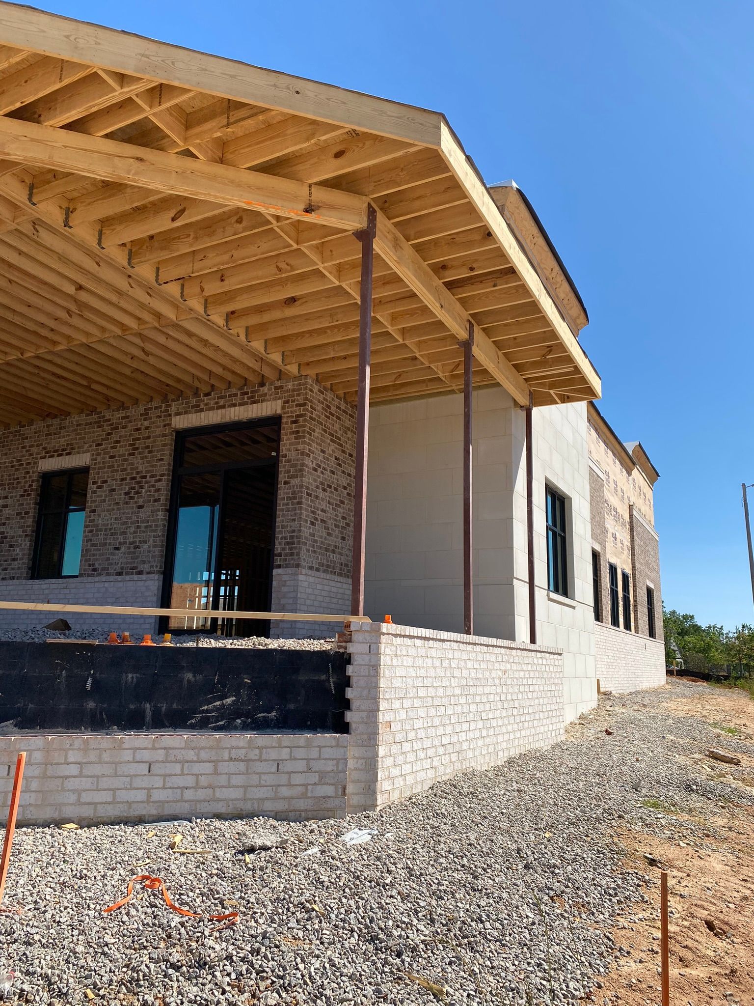 A house under construction with a wooden roof and a porch.