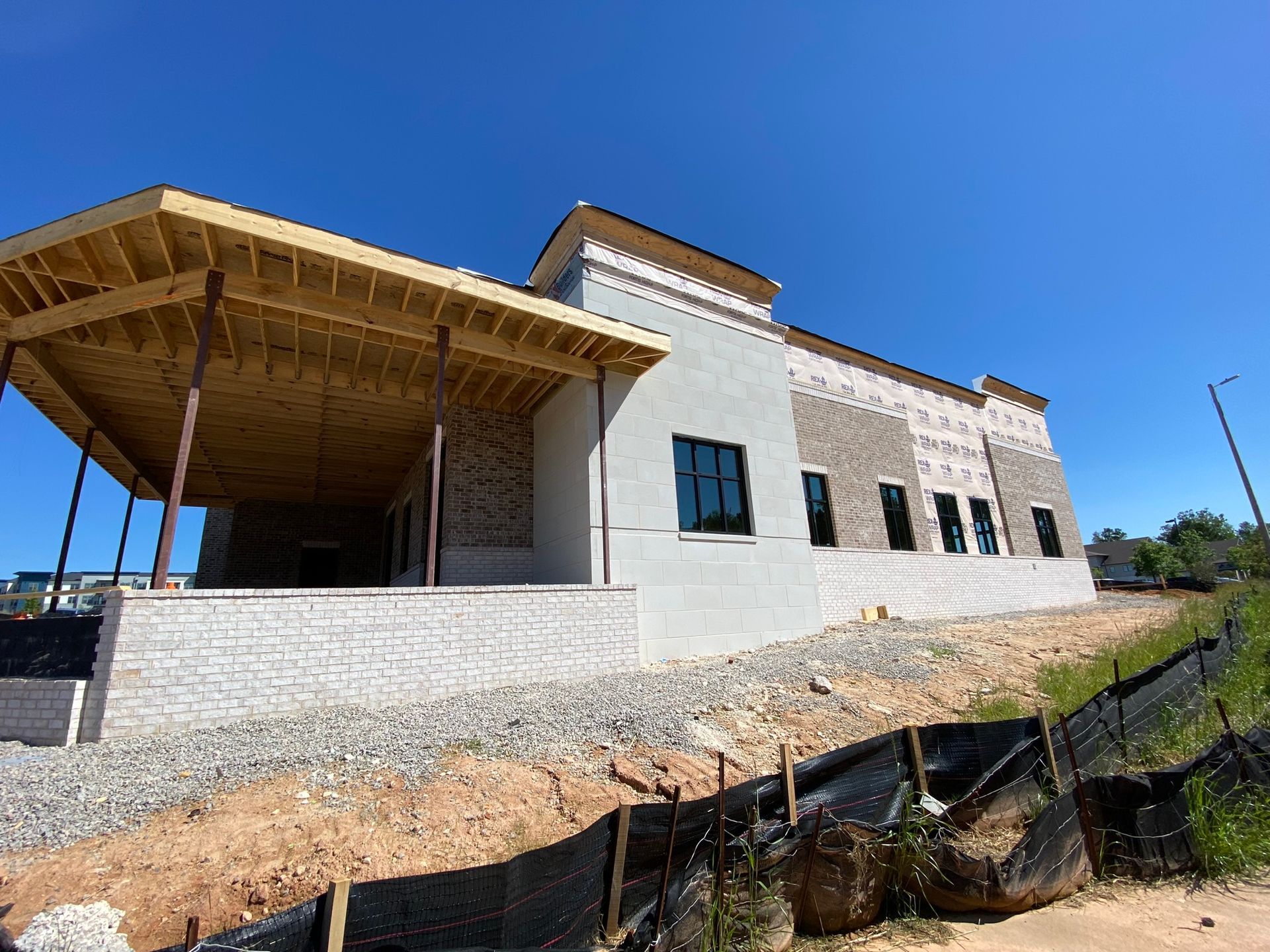 A large white building with a wooden roof is under construction.