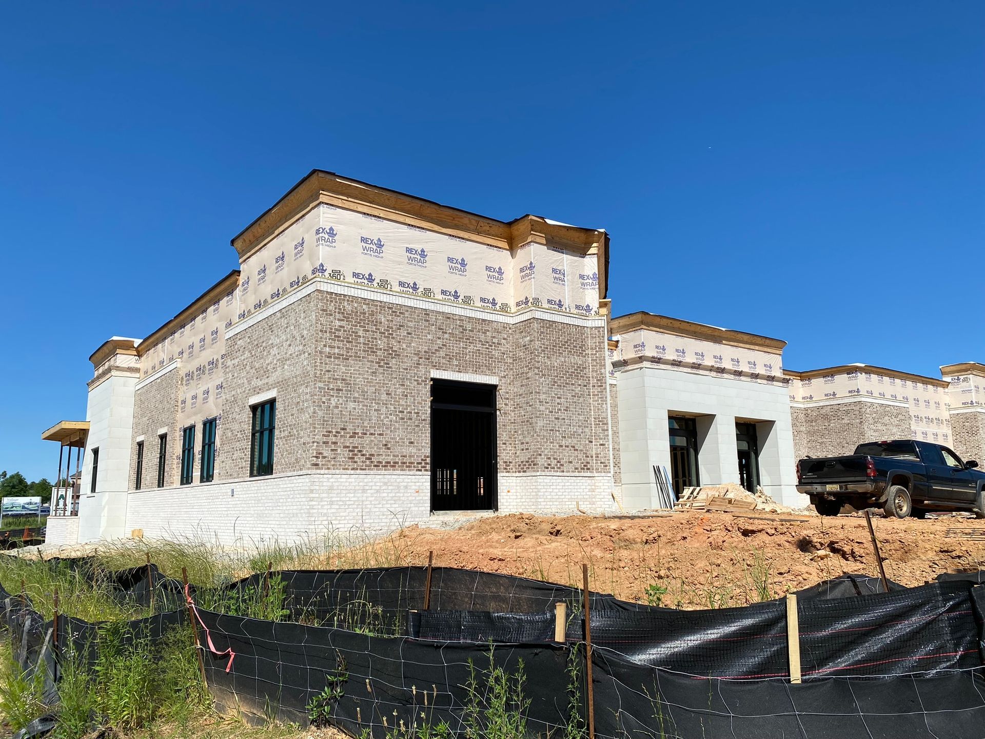 A large building under construction with a truck parked in front of it.